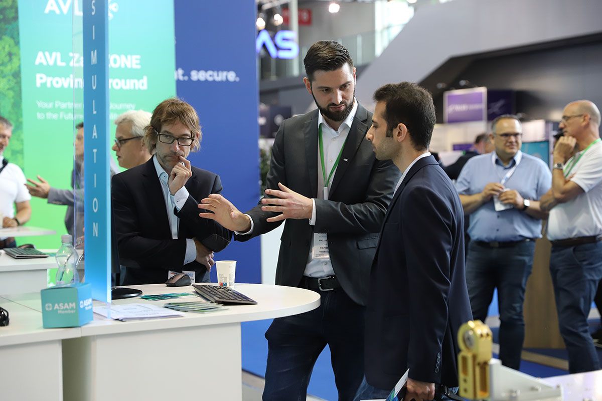 Photo shows an exhibitor at ADAS Expo talking to visitors about the tech on display
