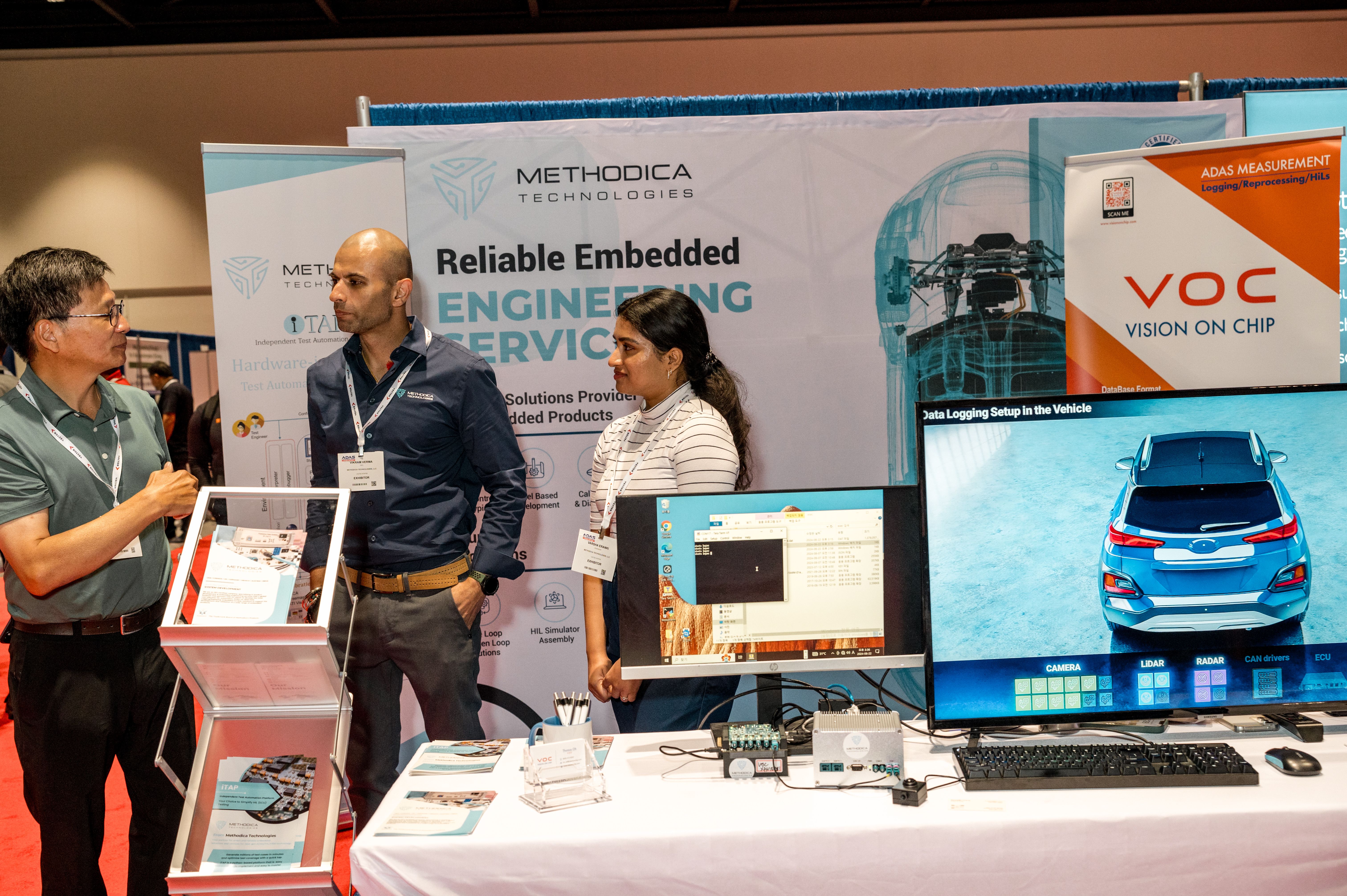 Photo shows a busy expo floor with visitors and exhibitors interacting on booth at ADAS California