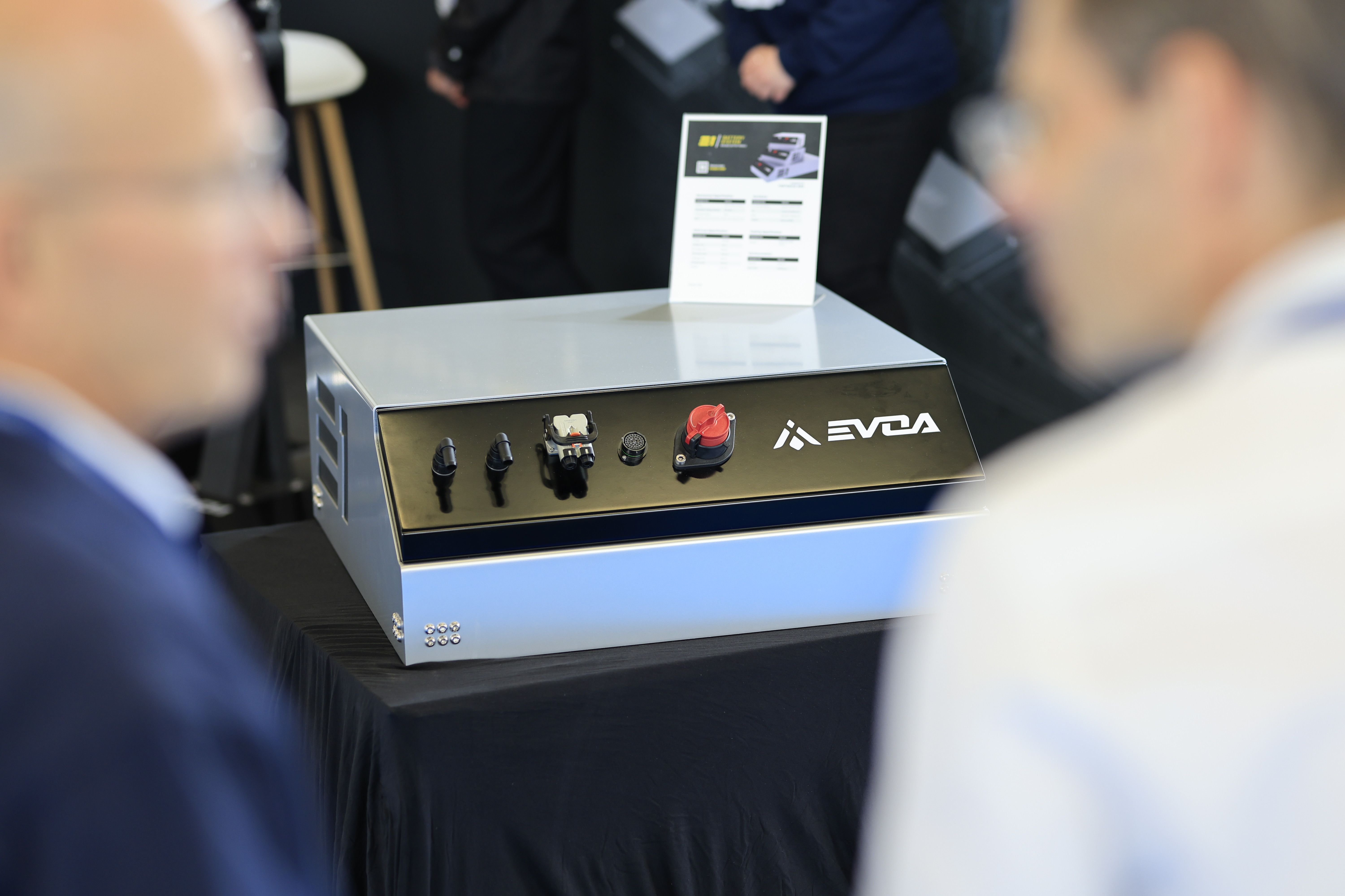 Photo shows technology on display at Electric & Hybrid Marine Expo with two people talking in the foreground