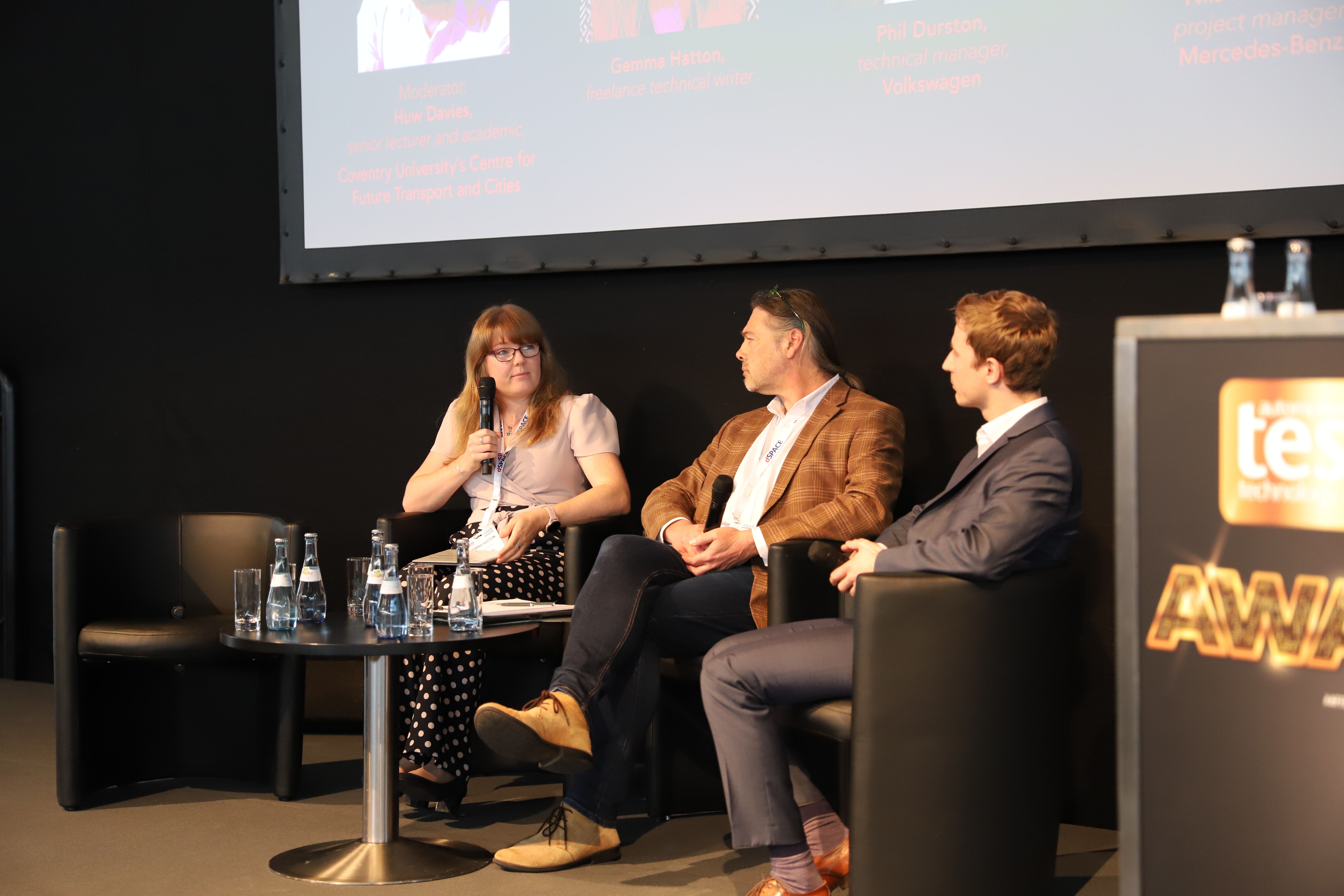 Photo shows a woman and two men having a discussion on the awards stage at the Automotive Testing Expo Europe 