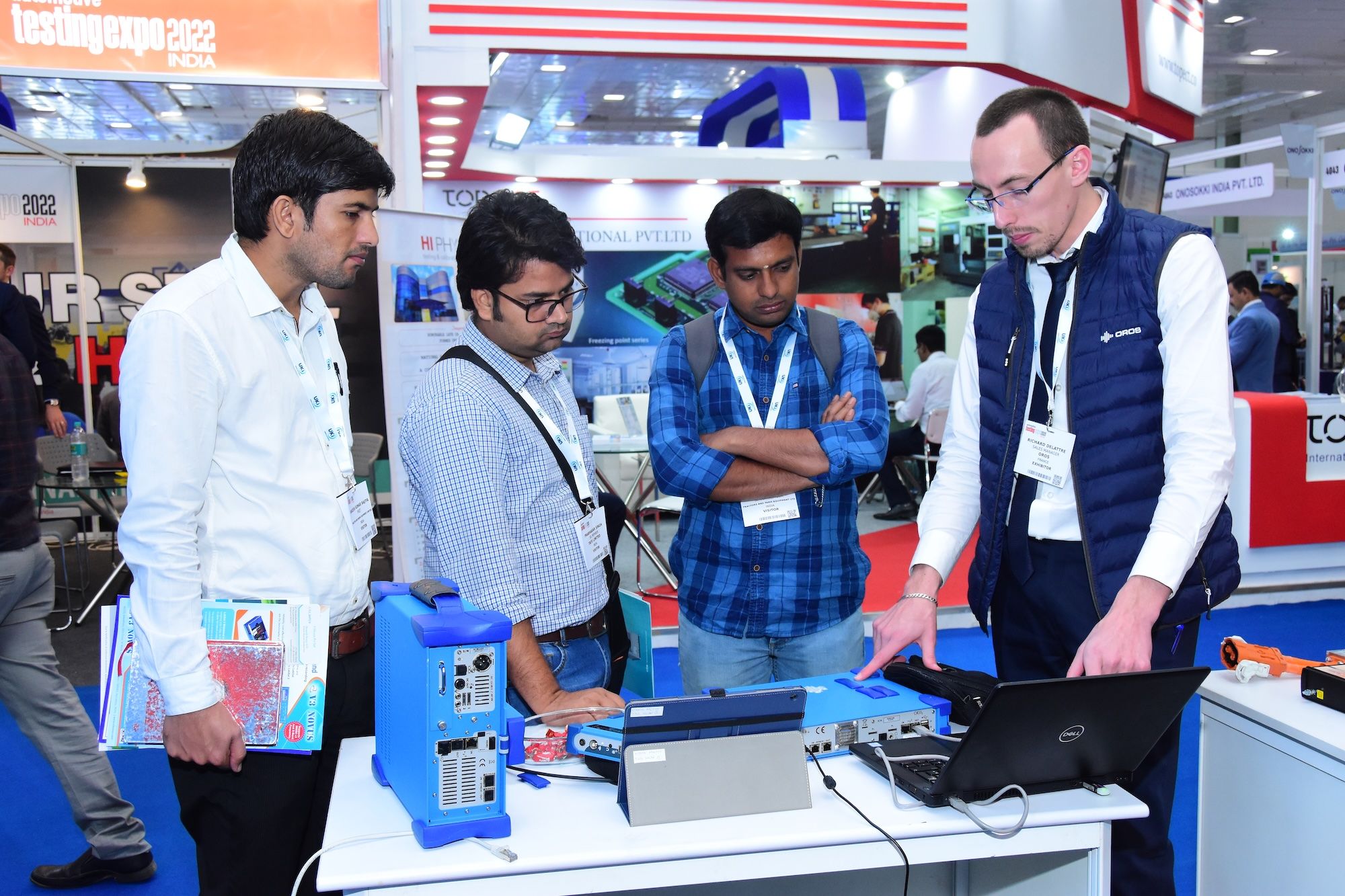 Photo shows an exhibitor at Automotive Testing Expo India discussing the technology on their booth to engaged visitors