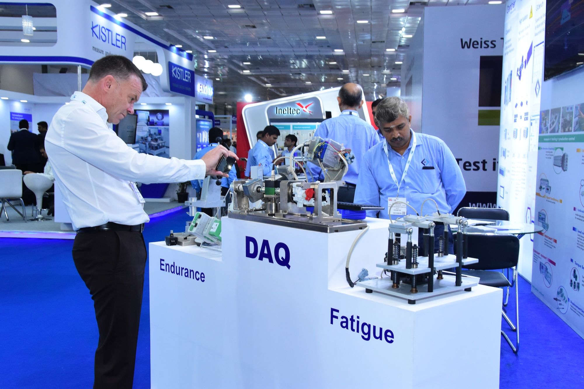 Photo shows a visitor at Automotive Testing Expo India taking a photo of the innovative tech an exhibitor is showcasing