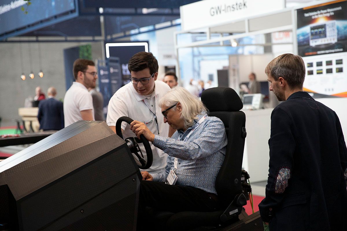 Photo shows a visitor at the Automotive Testing Expo getting a demo of innovative tech