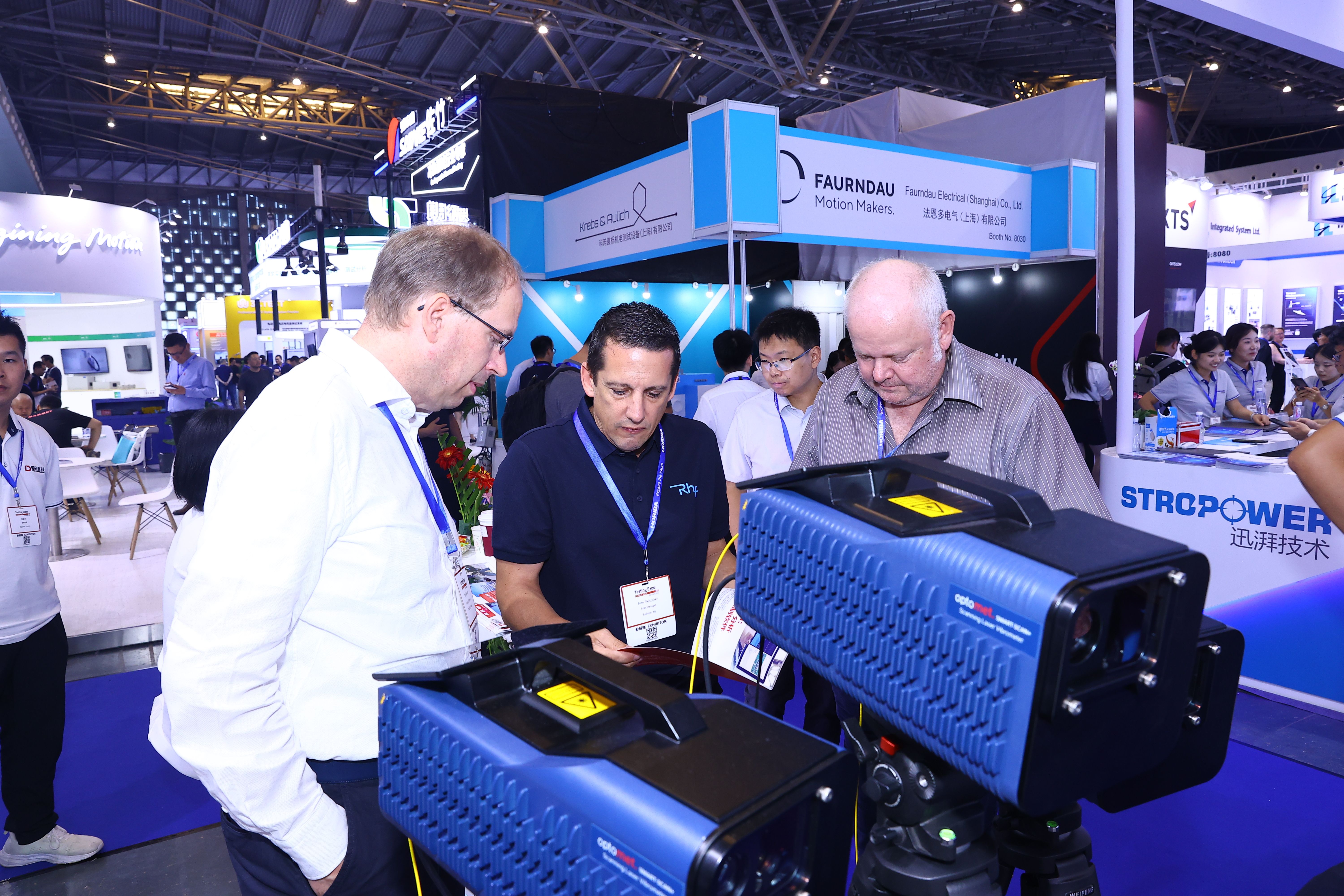 Image shows an exhibitor showing a group of engaged visitors the technology they are showcasing on a vehicle at Testing Expo China Automotive