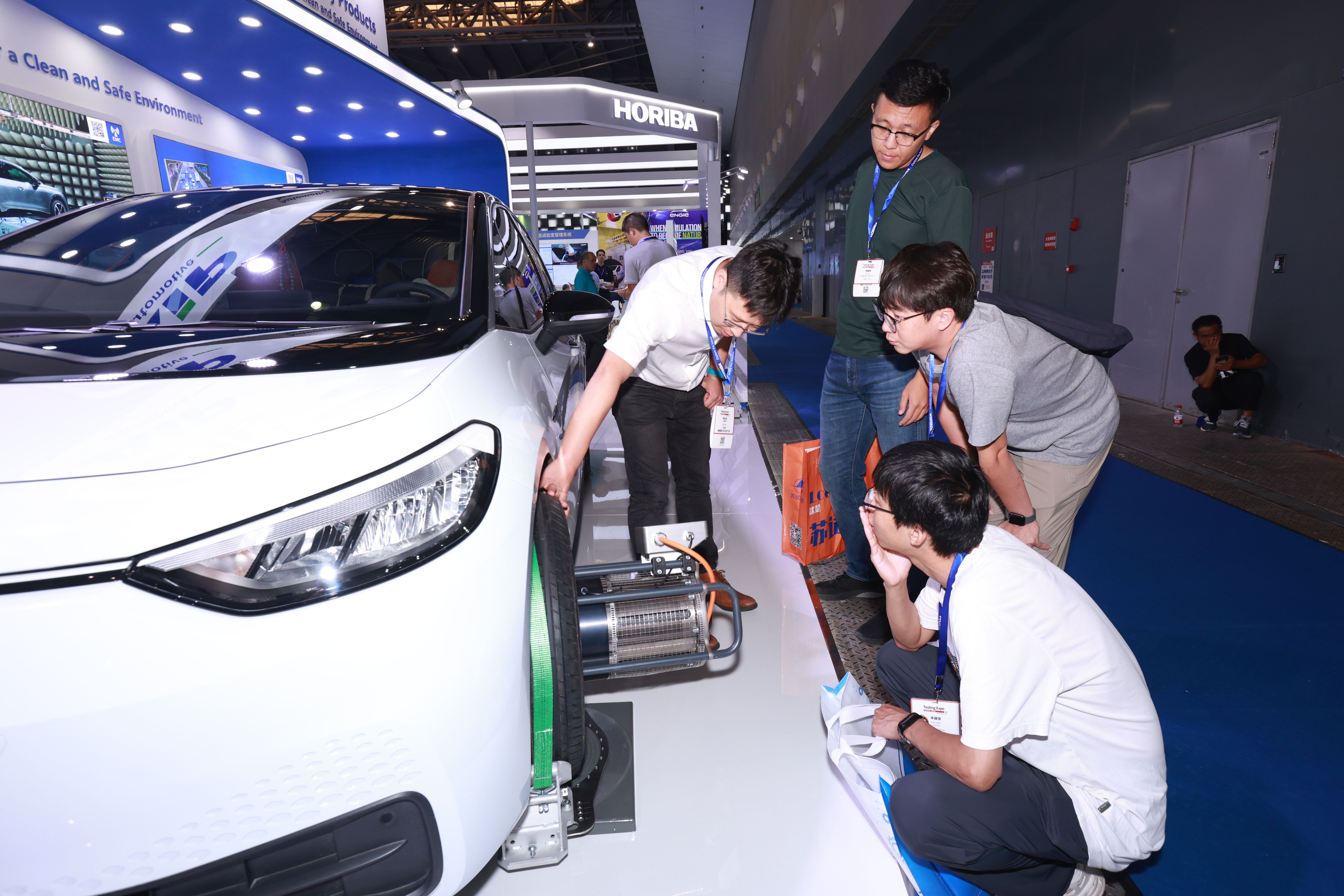 Image shows an exhibitor showing a group of engaged visitors the technology they are showcasing on a vehicle at Testing Expo China Automotive