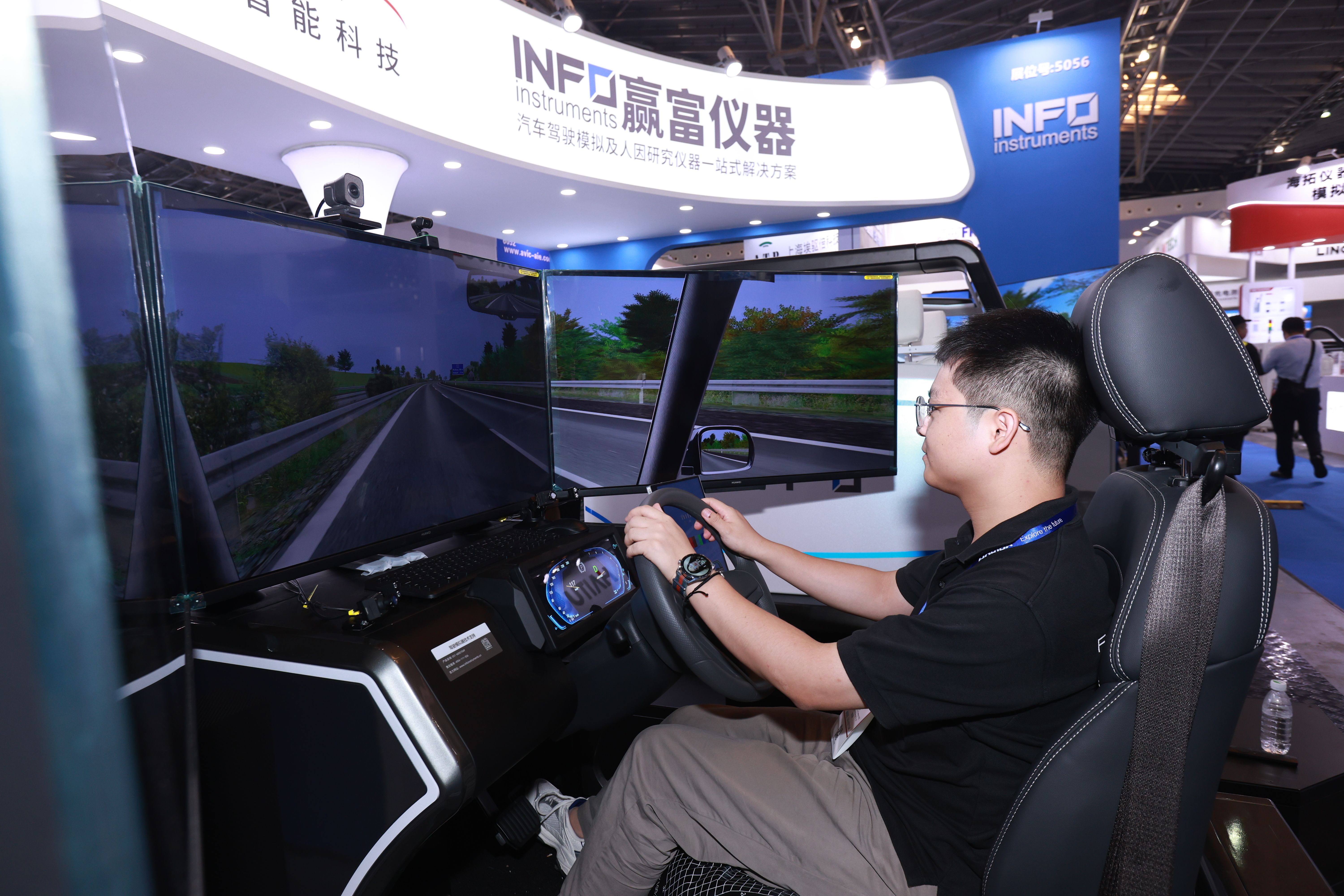 Photo shows a visitor having a demo of simulation technology at Testing Expo China Automotive