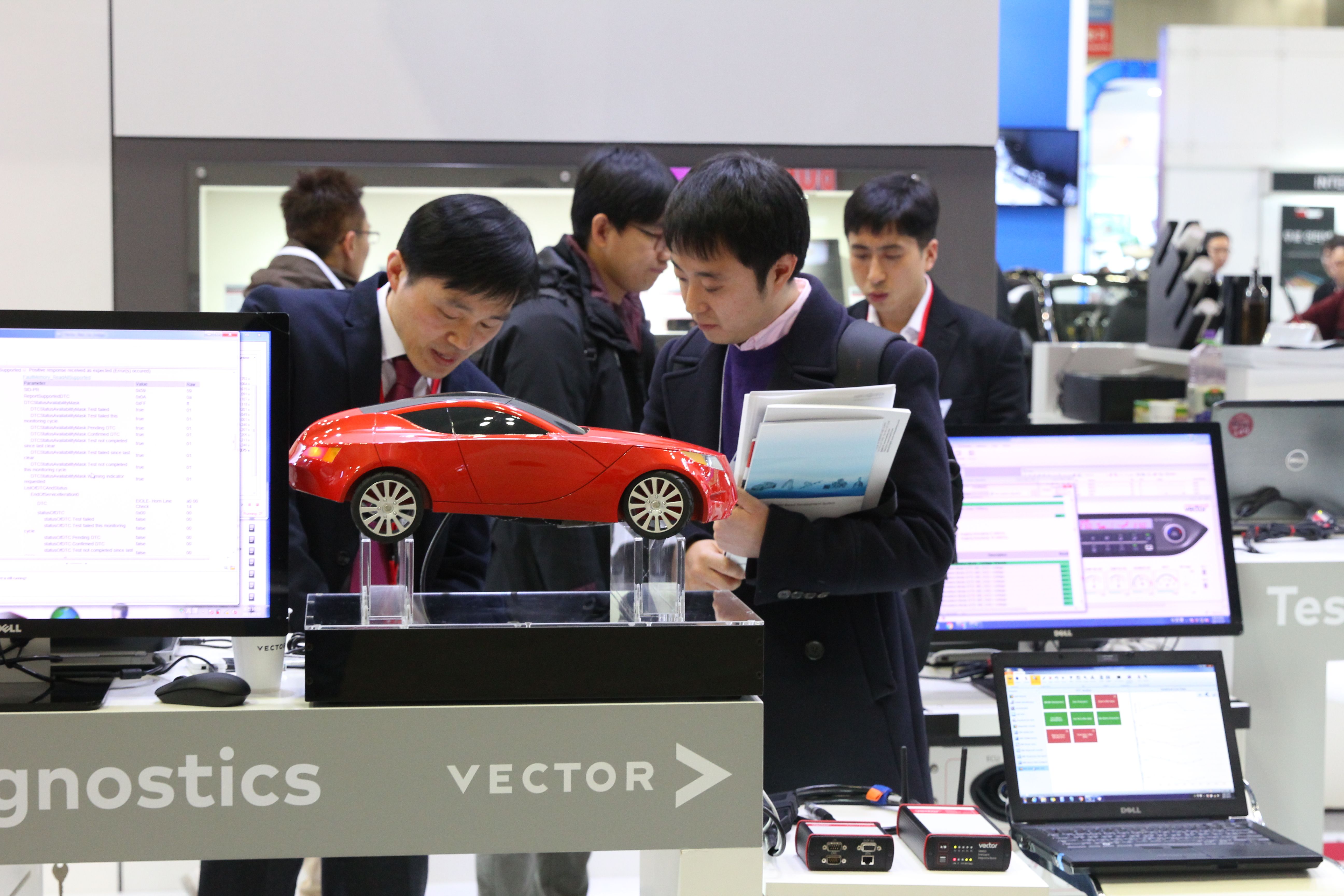 Photo shows visitors looking at technology on show at Automotive Testing Expo Korea