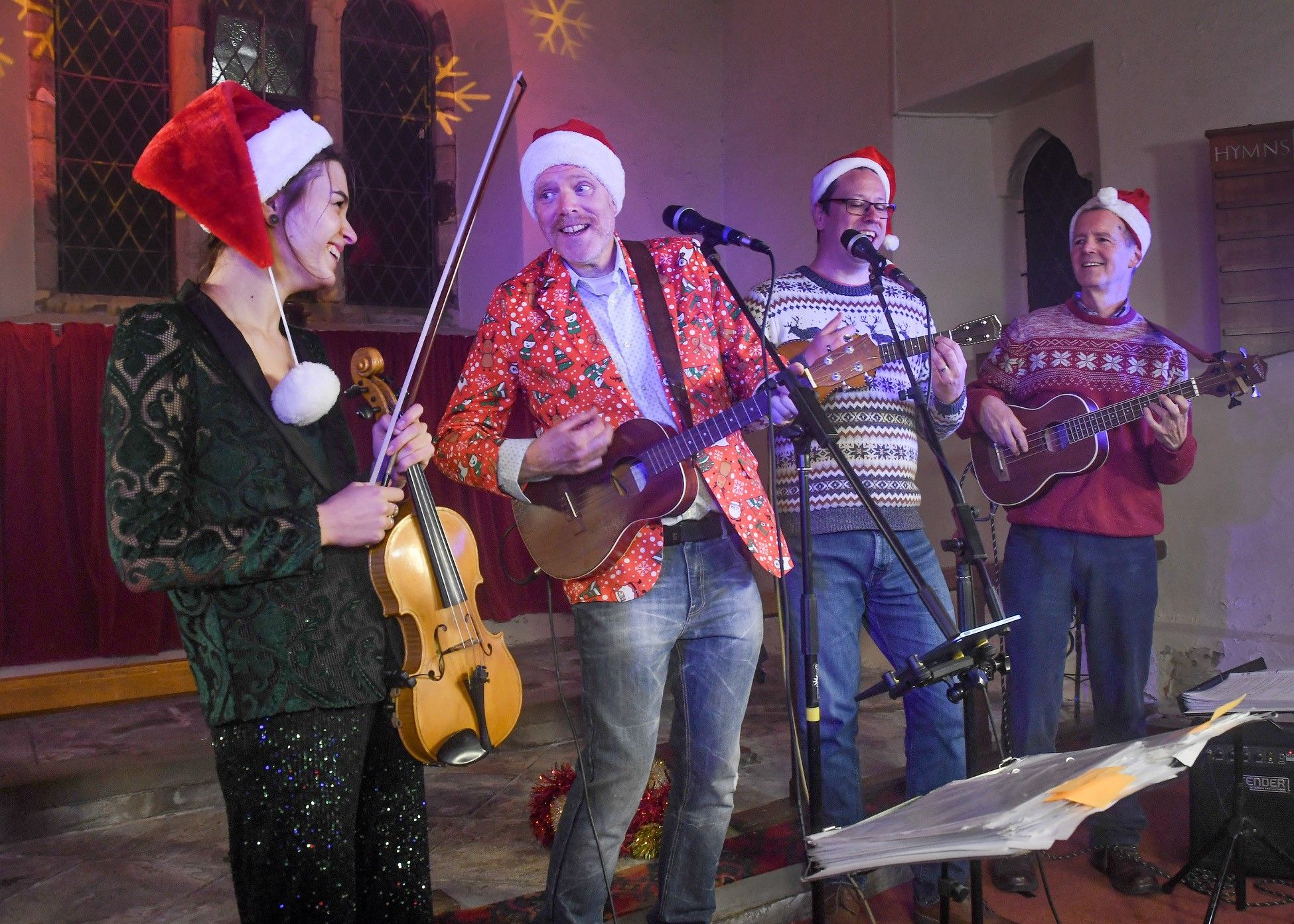 Four people singing at the Christmas sing along