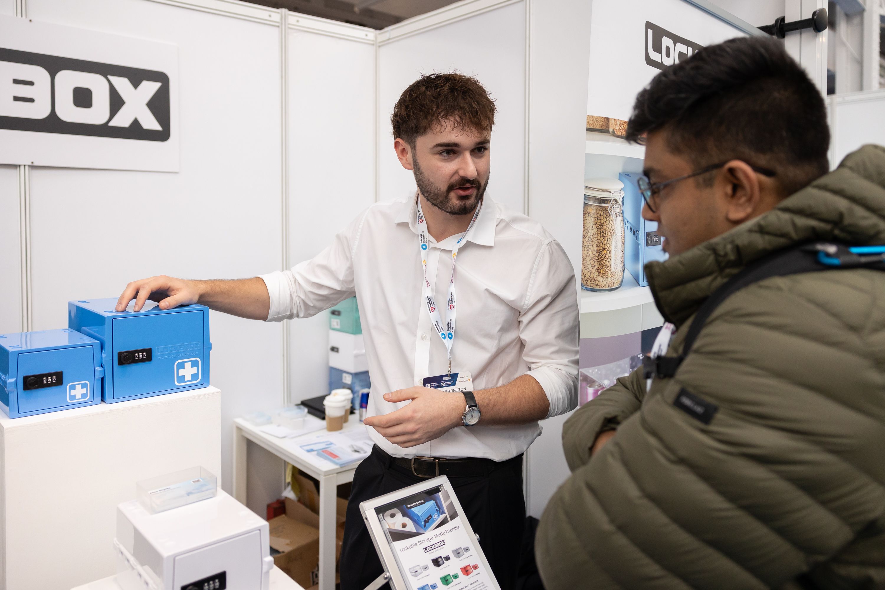 A delegate talking to a potential customer on the lockerbox stand about their products