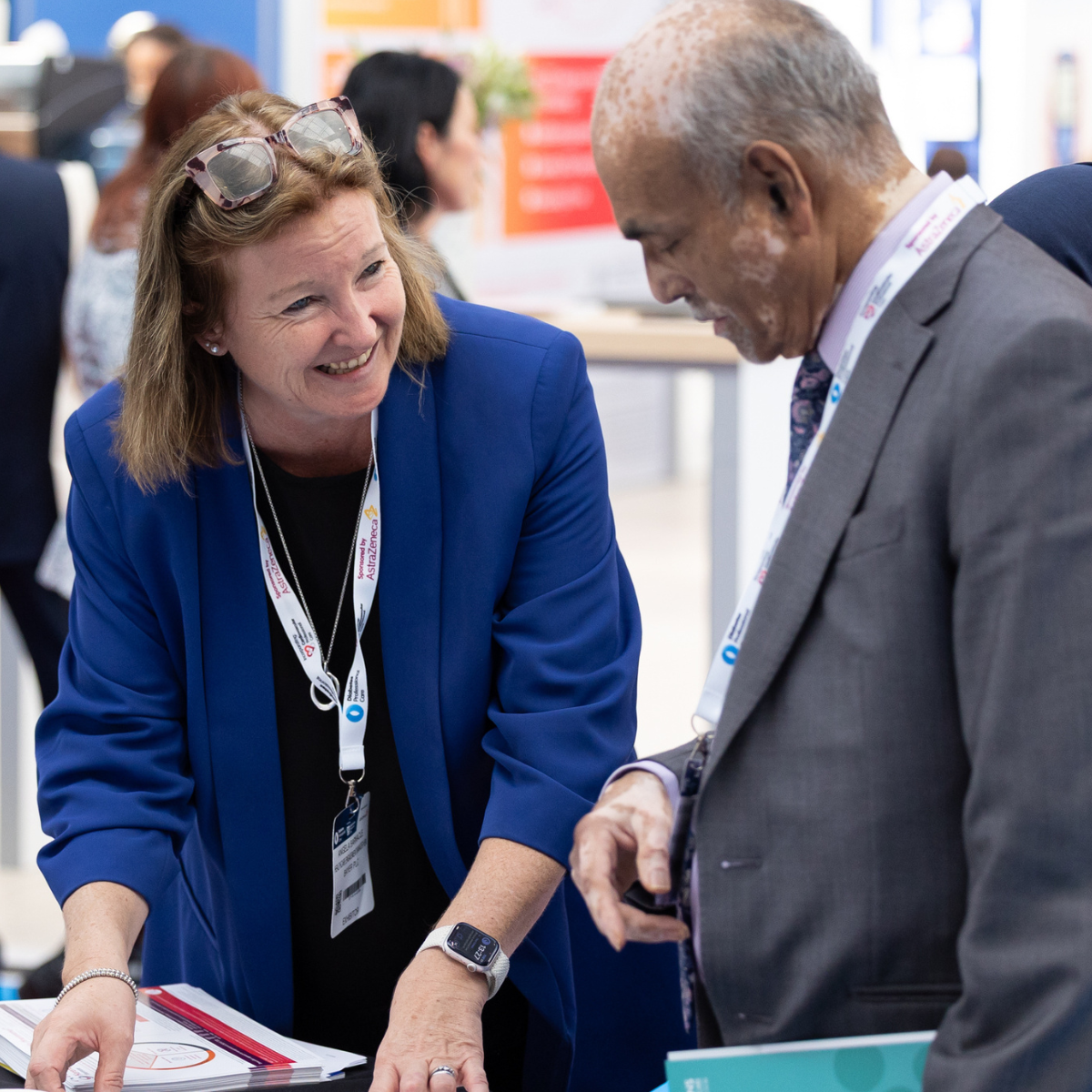 A happy exhibitor at CVRM professional care smiling at a GP as they discuss products