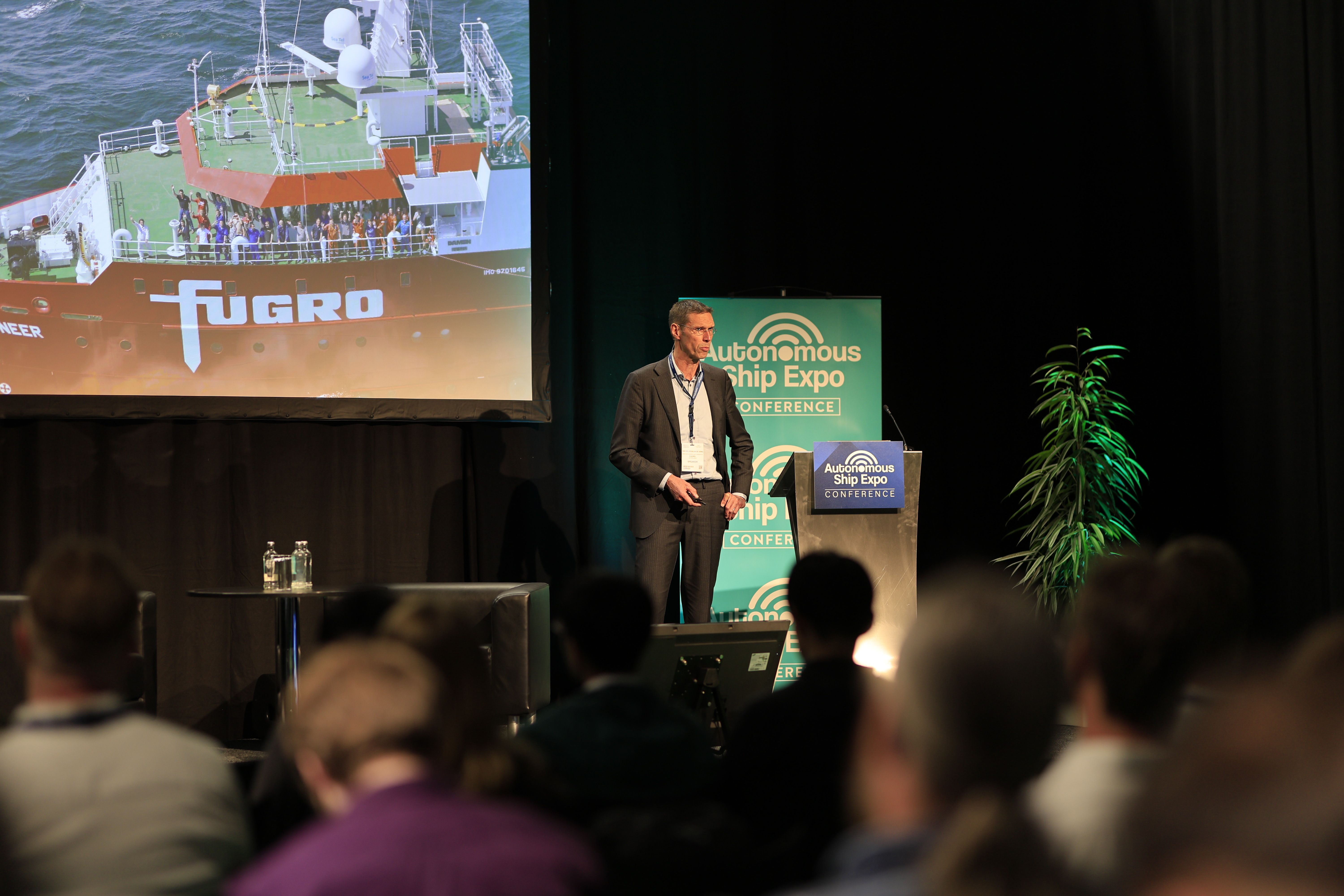 Photo shows a speaker presenting to an engaged audience at Autonomous Ship Expo