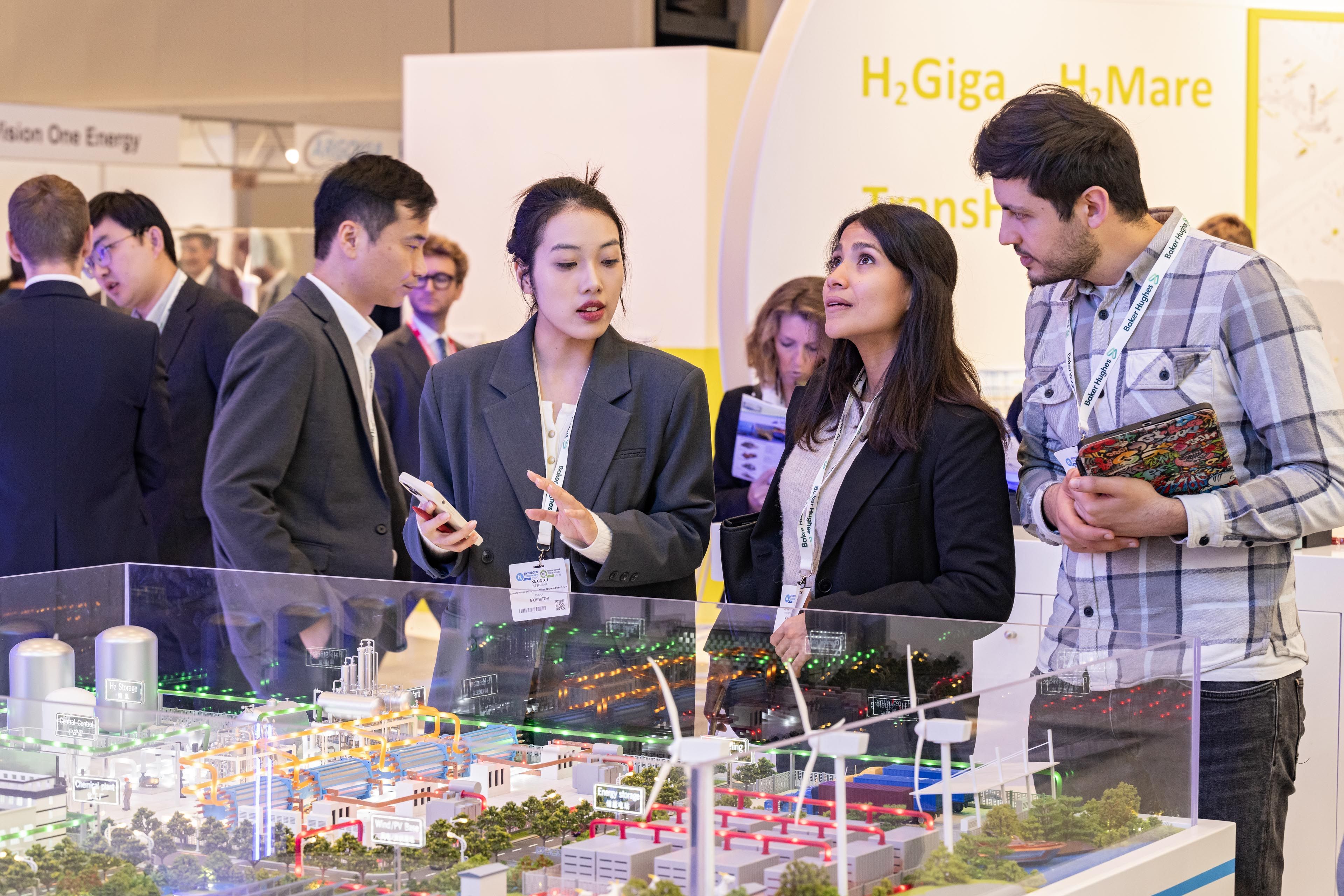 Visitors at an exhibition stand looking at and discussing a play