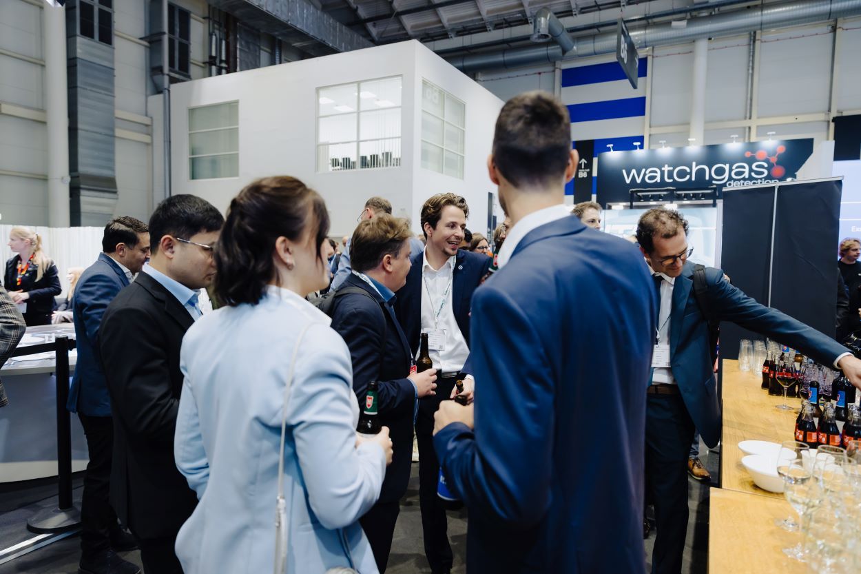 Visitors at an exhibition stand looking at and discussing a play