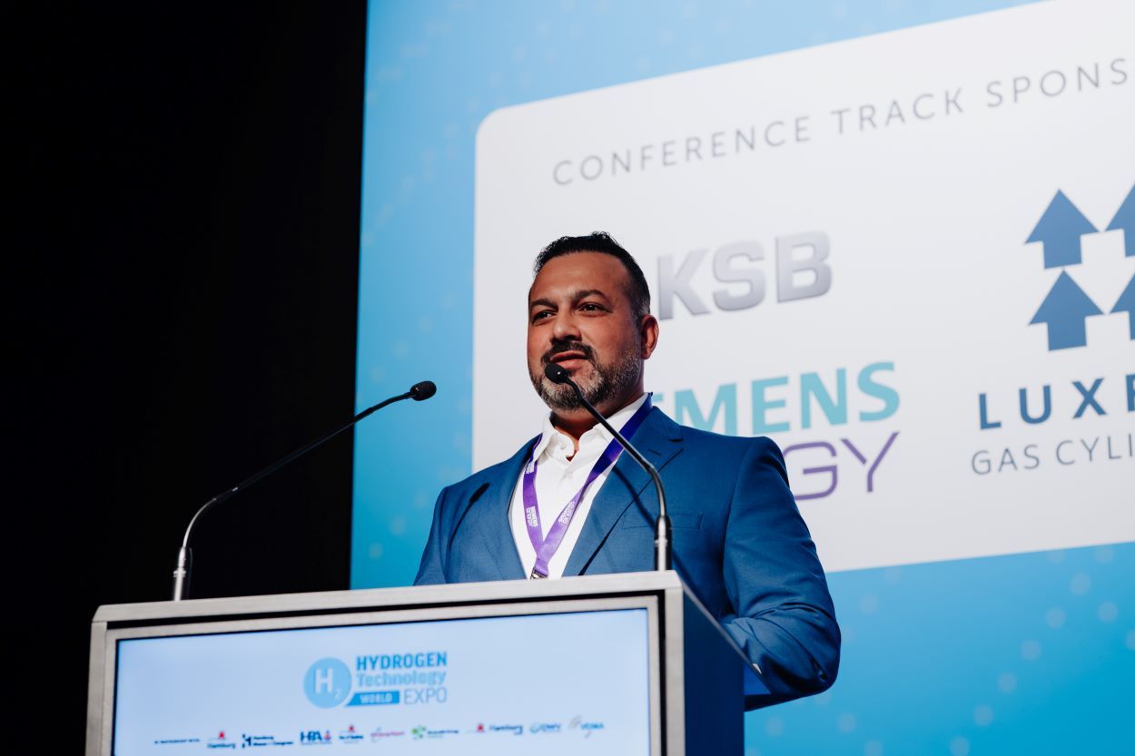 speaker on stage behind plinth