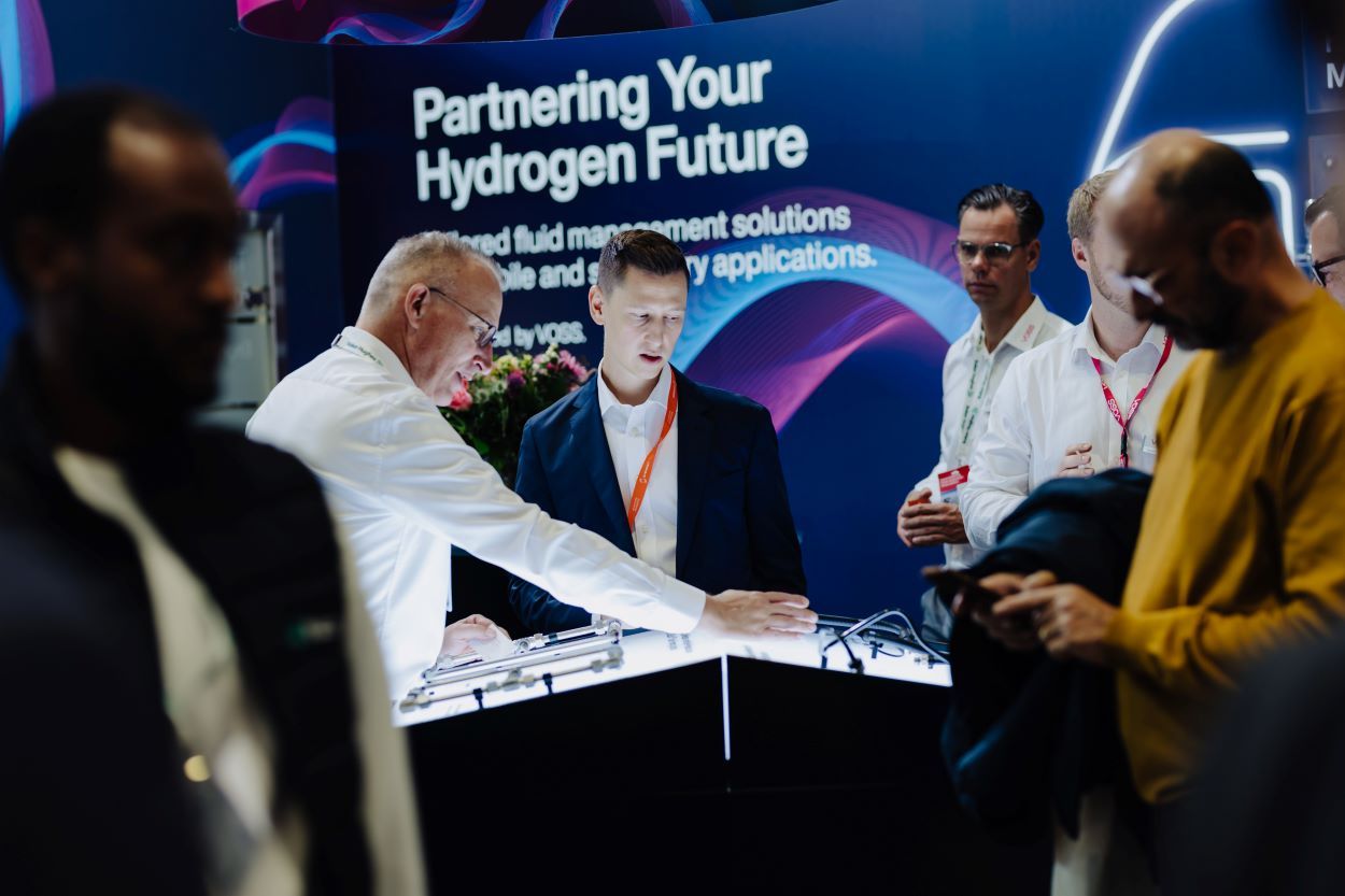 Men standing on an busy exhibition stall related image