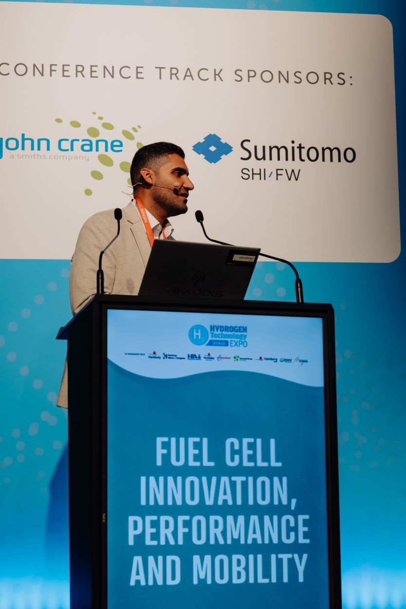 3 speakers presenting a panel on stage