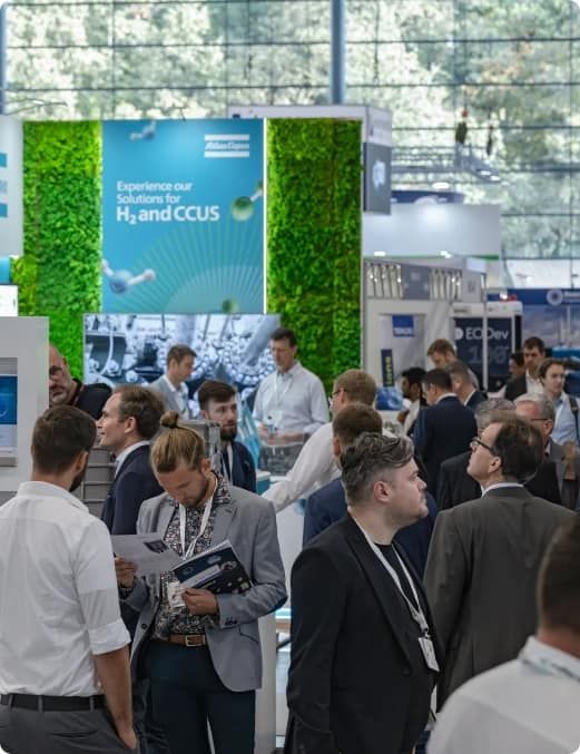 A busy expo hall with large stand builds in the background