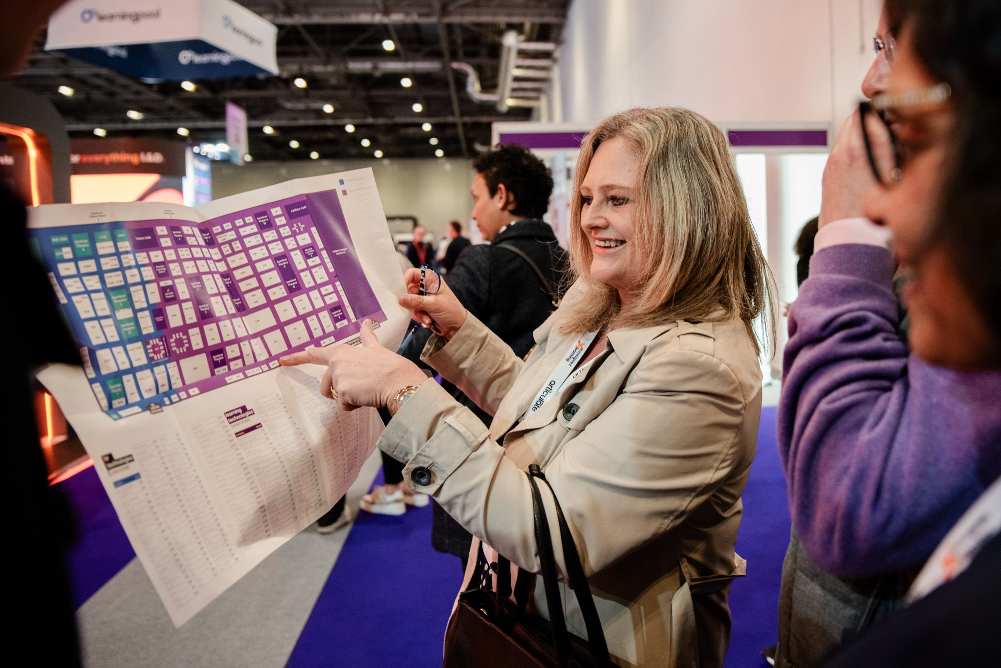 Visitors looking at a shared floor plan of HR Technologies UK and Learning Technologies UK