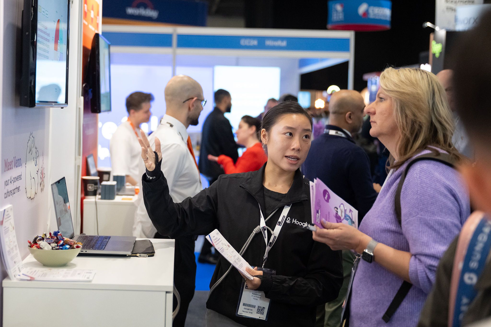 Woman concentrating on what an exhibitor from HR Technologies UK is saying