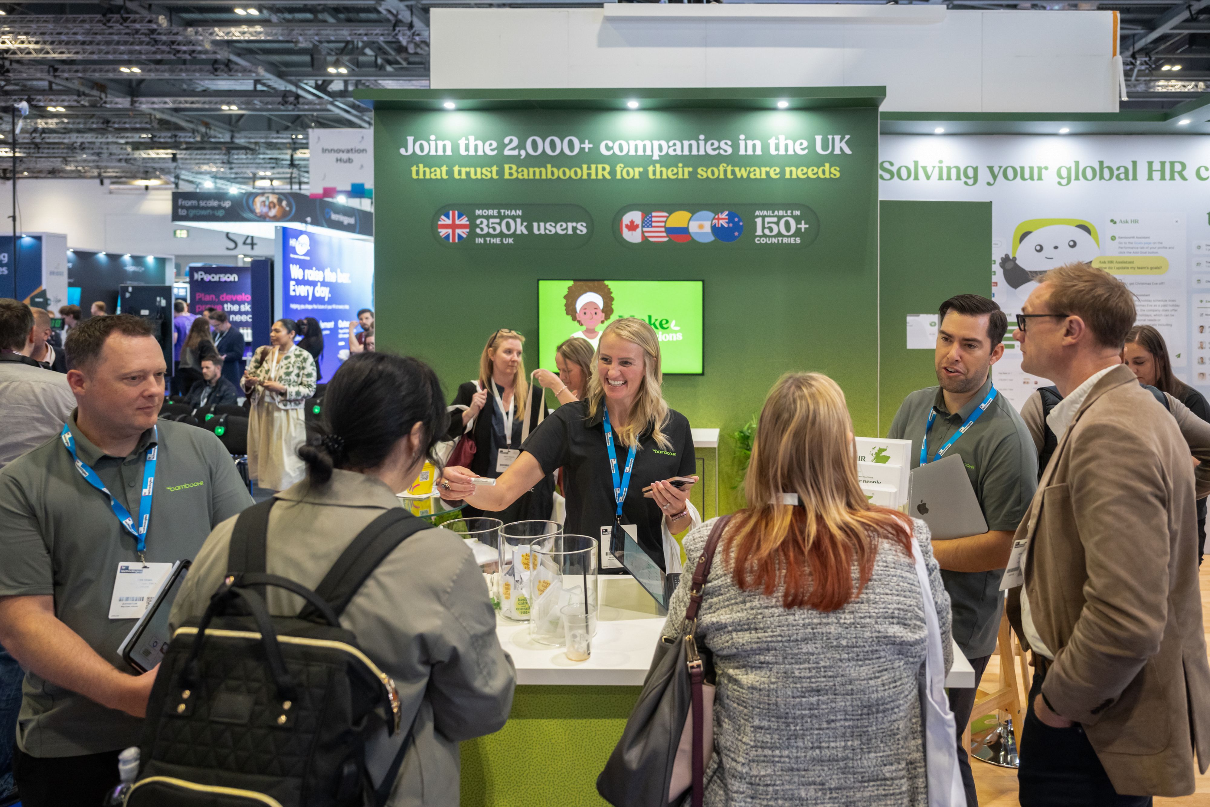 A crowd of people gathered around a stand at HR Technologies UK