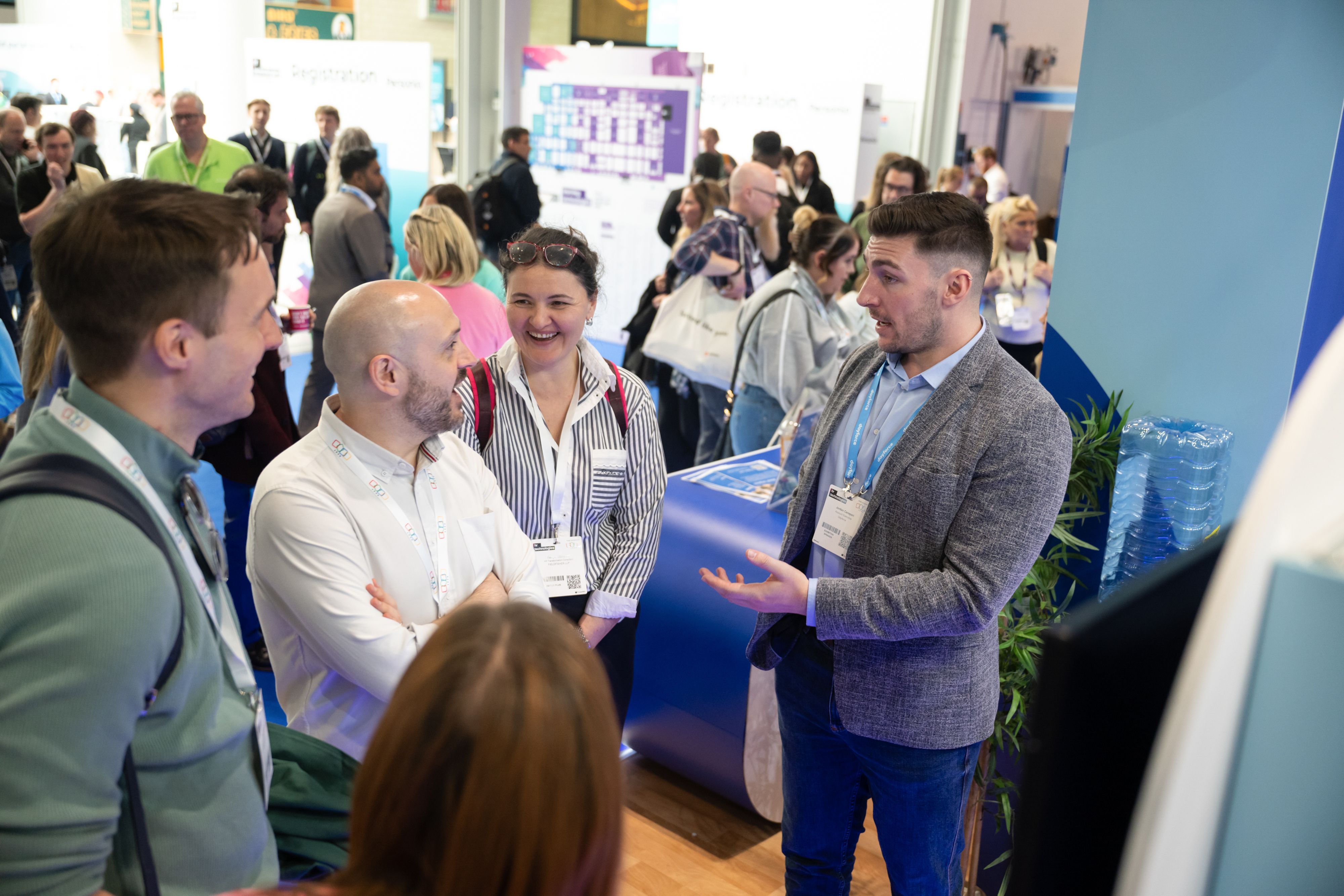 A conversation between a group of four people at en exhibitor's stand at HR Technologies UK