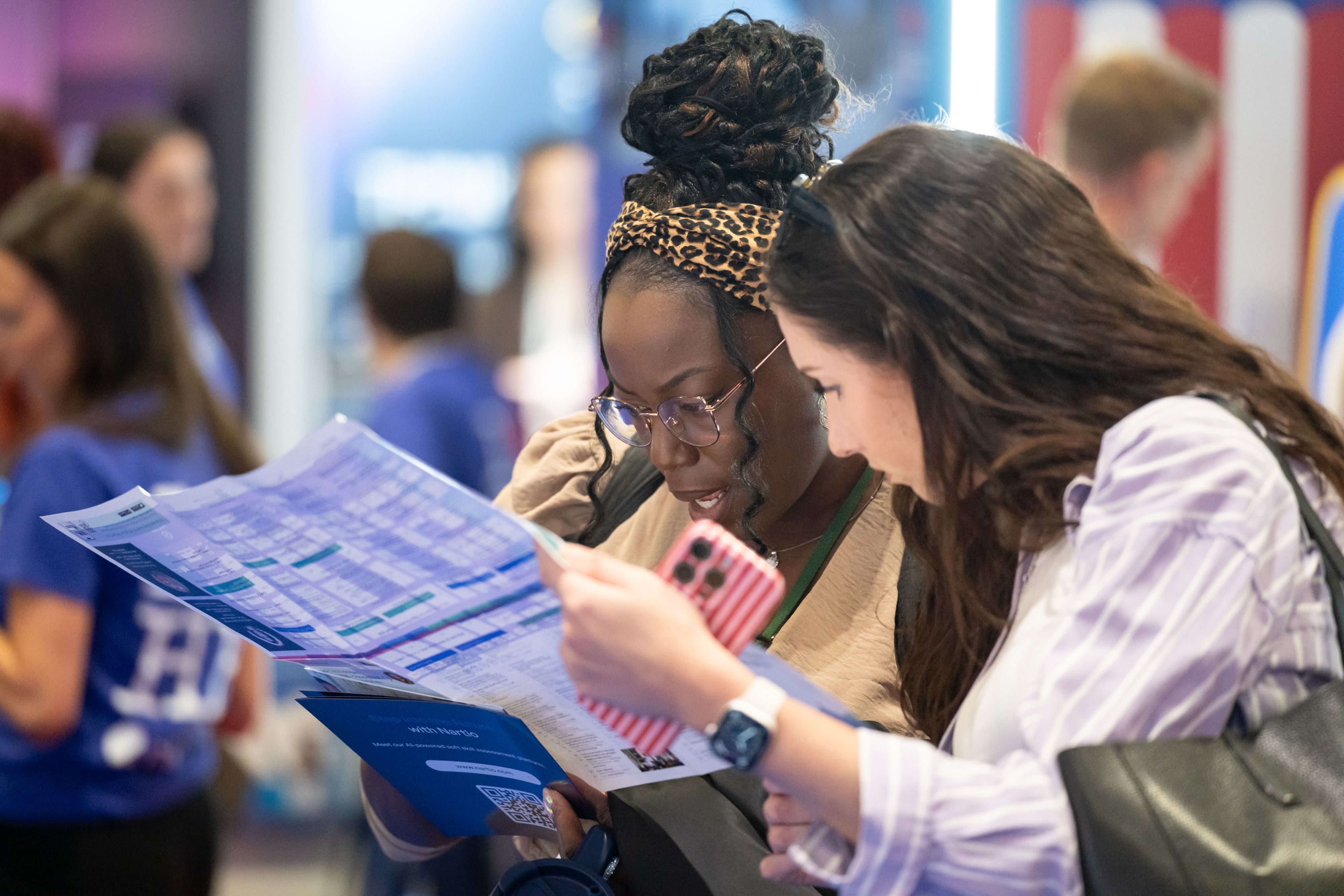 Two visitors reading the pocket guide at HR Technologies UK