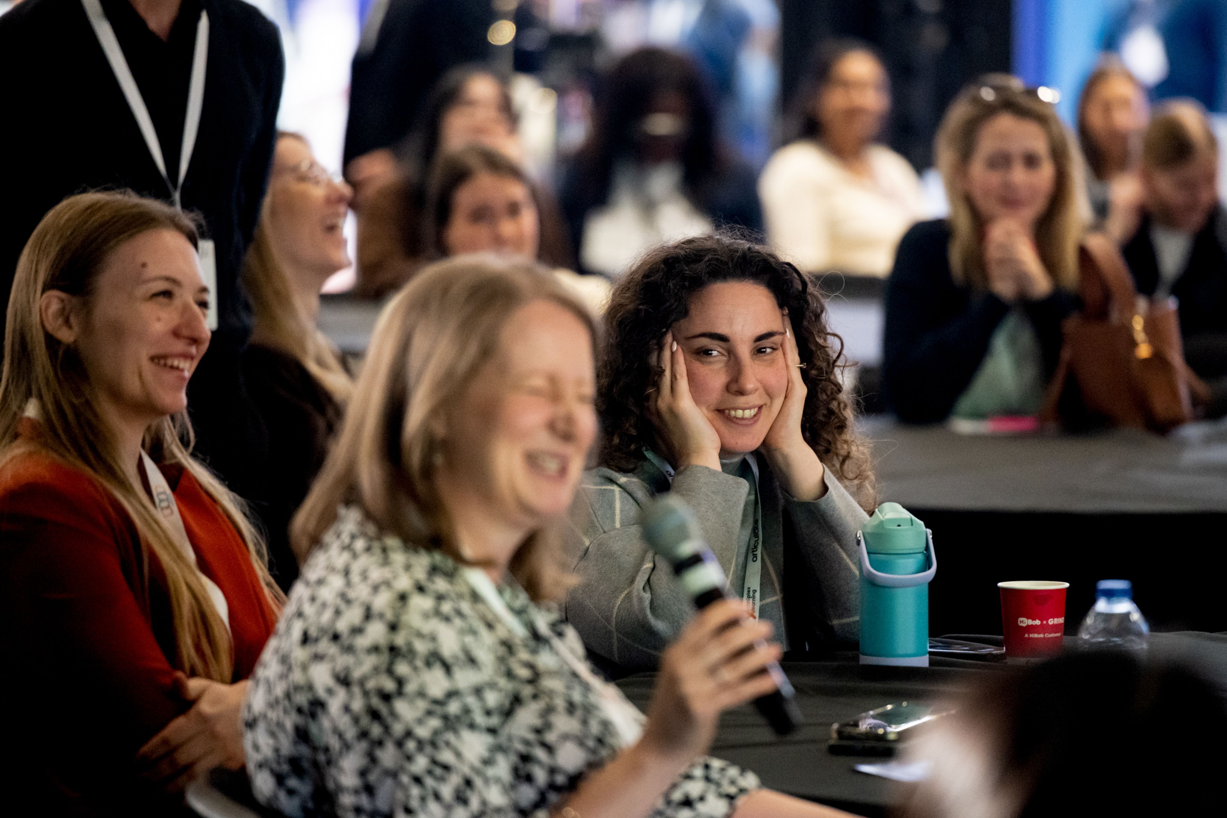 A woman reacting with surprise to something another woman is saying at a Keynote session at HR Technologies UK