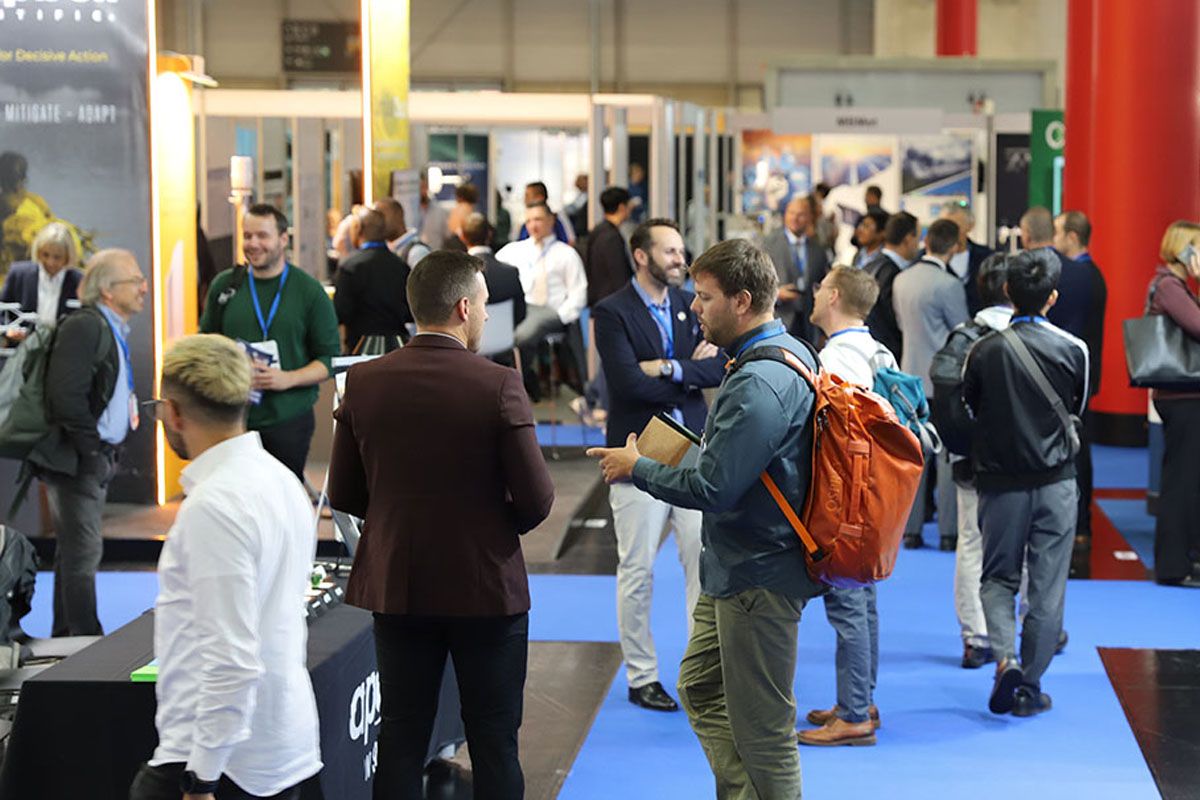 Photo shows a busy expo floor with visitors and exhibitors networking at Met Tech World Expo
