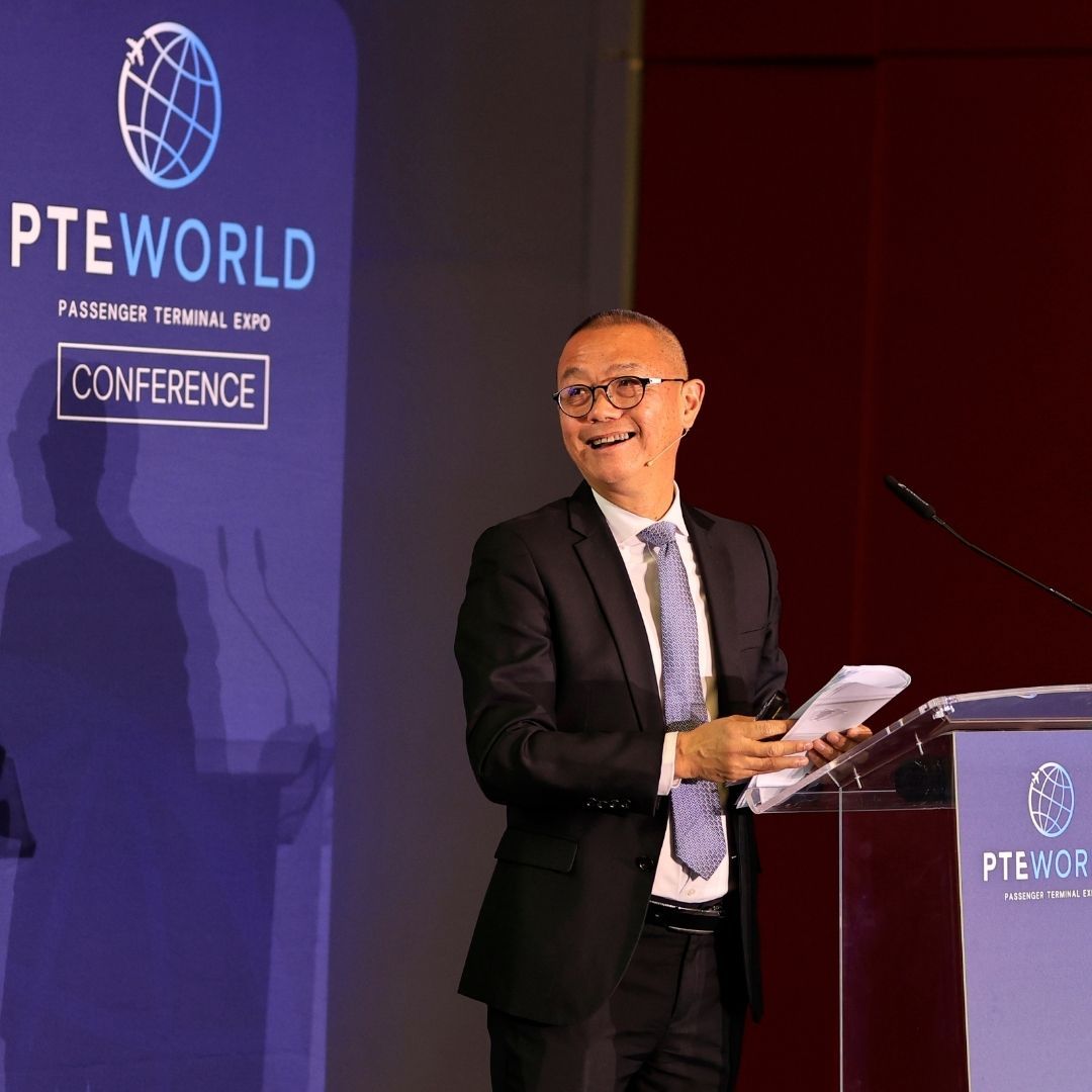 Photo shows speaker on stage at PTE World Conference