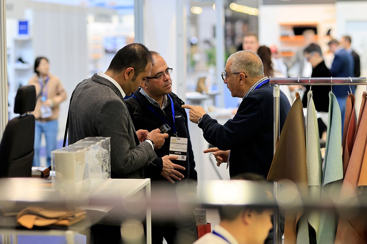 Photo shows visitors and exhibitors networking at Automotive Interiors Expo