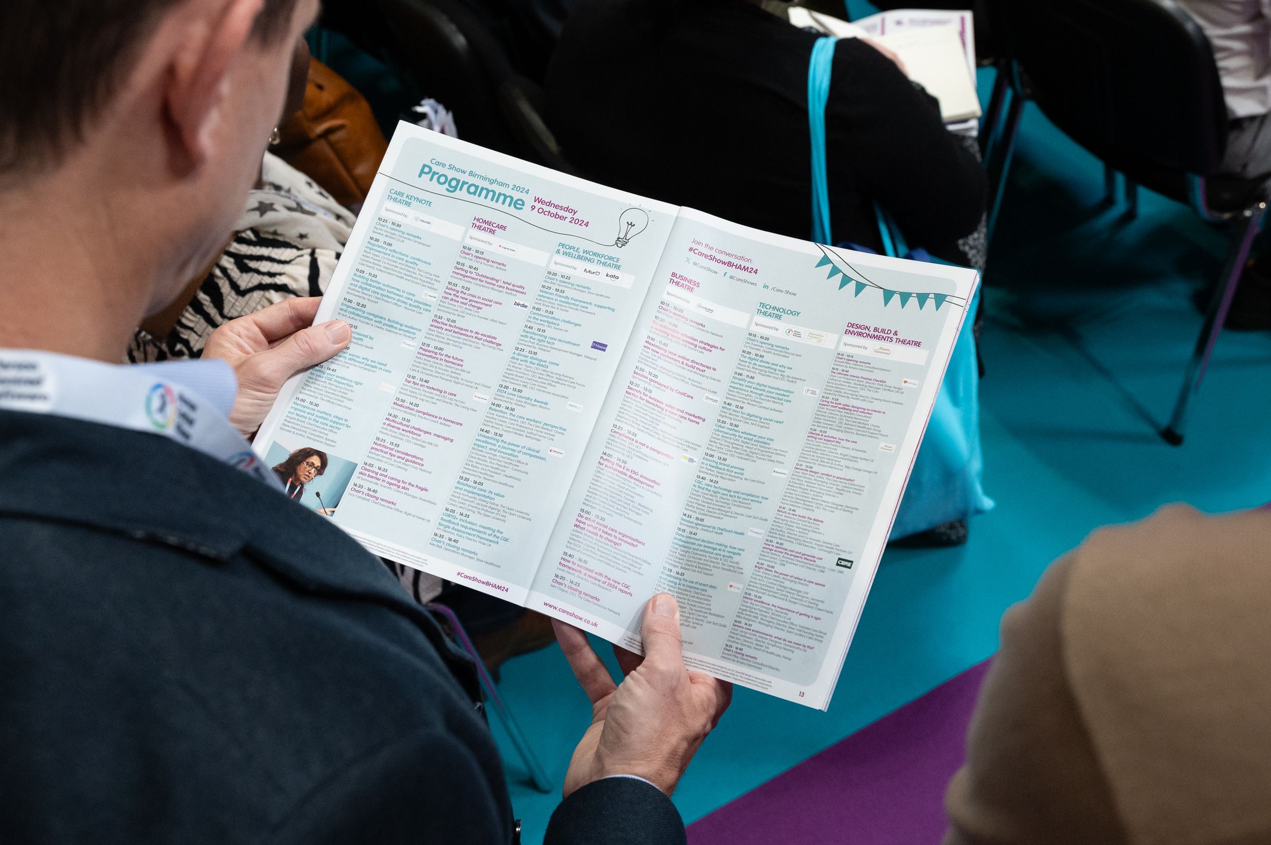 Man reading the conference programme from the Care Show show guide