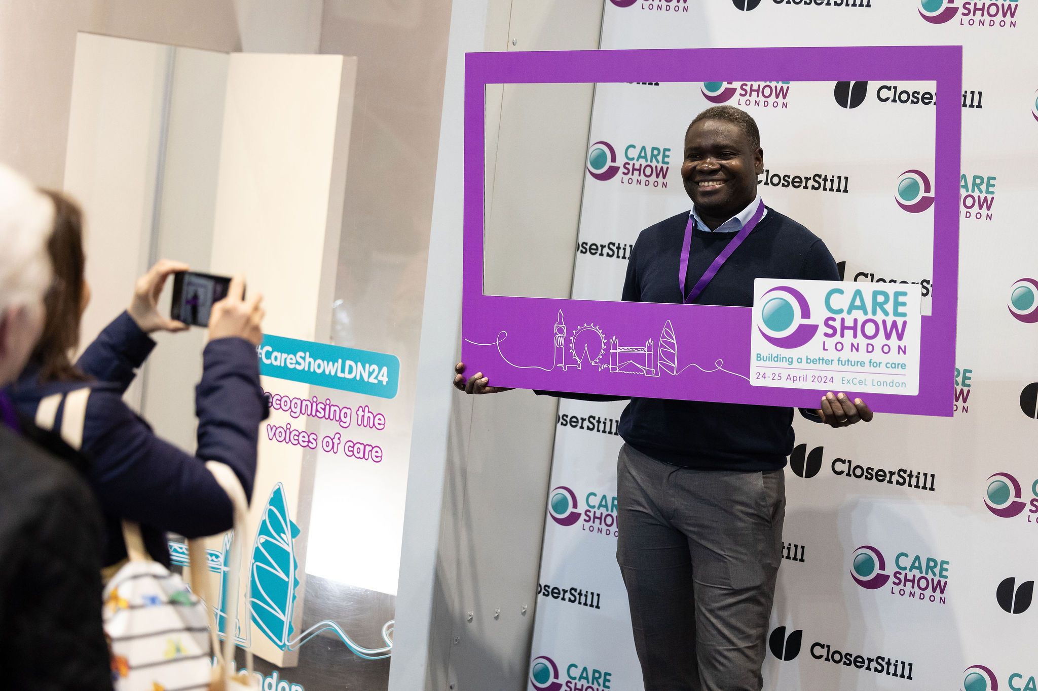 Man smiling taking a picture in the selfie zone