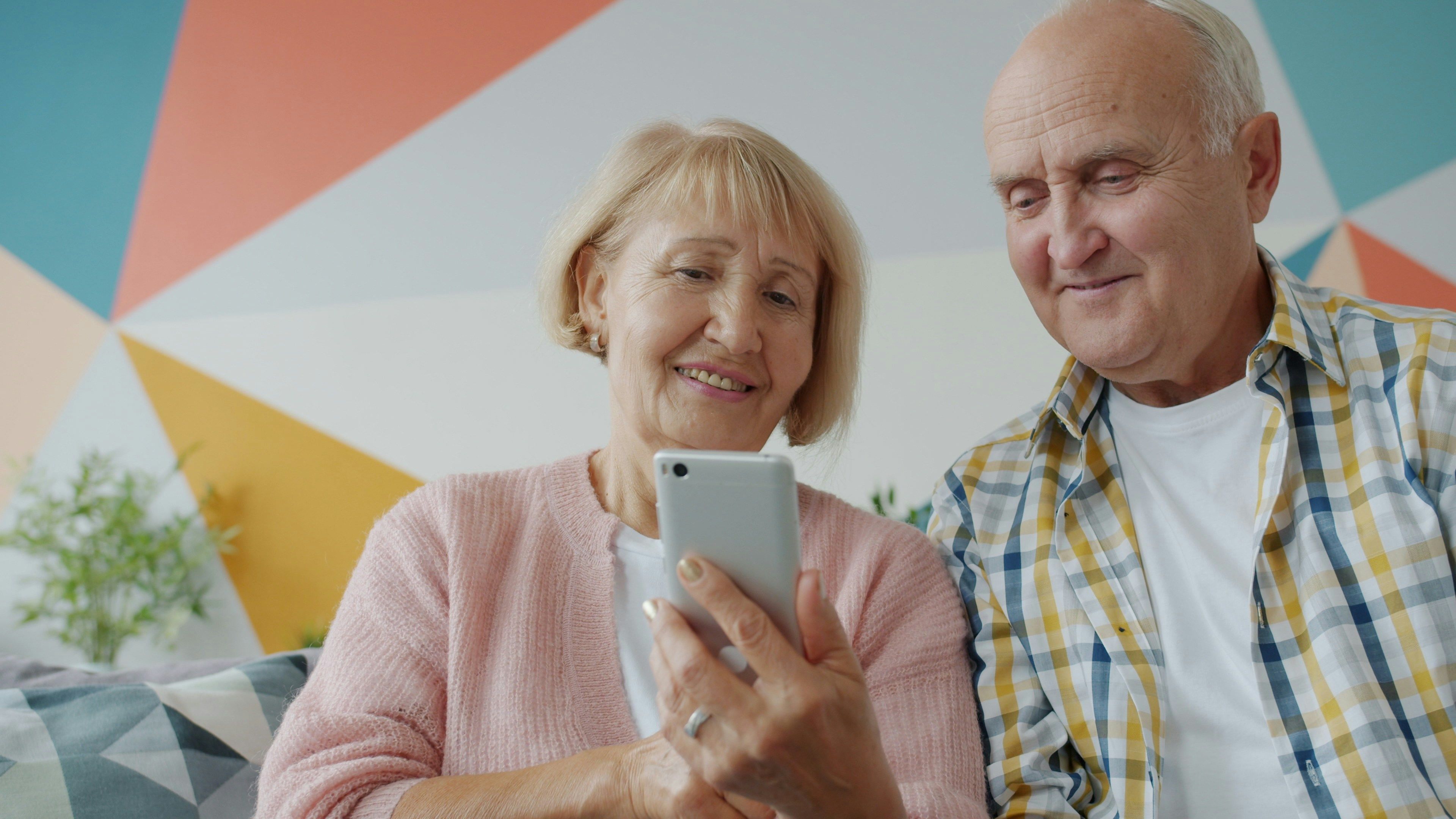 elderly couple looking at a smartphone together