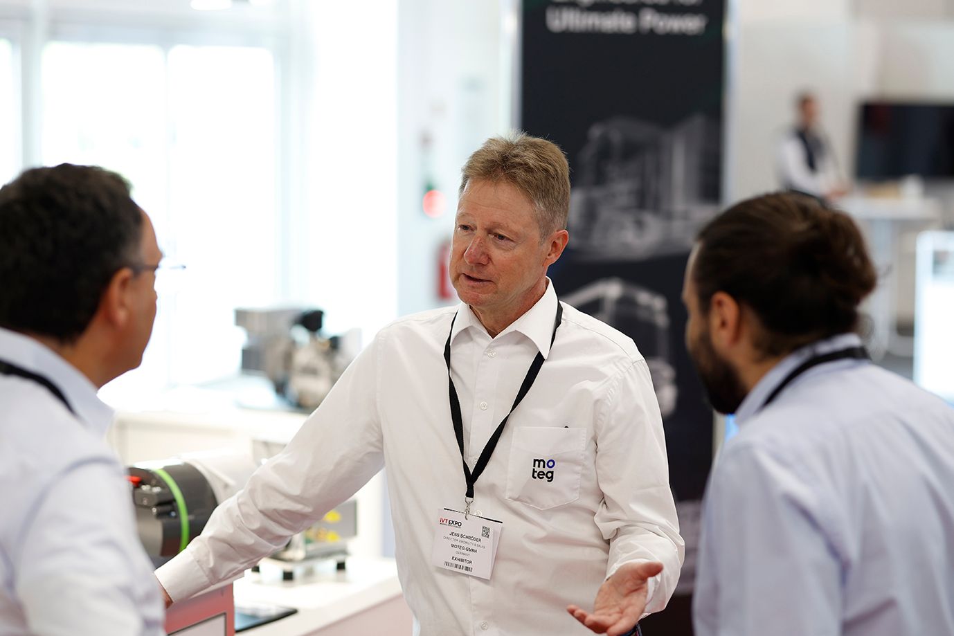 Photo shows an exhibitor explaining tech on their stand to visitors at iVT Expo Europe