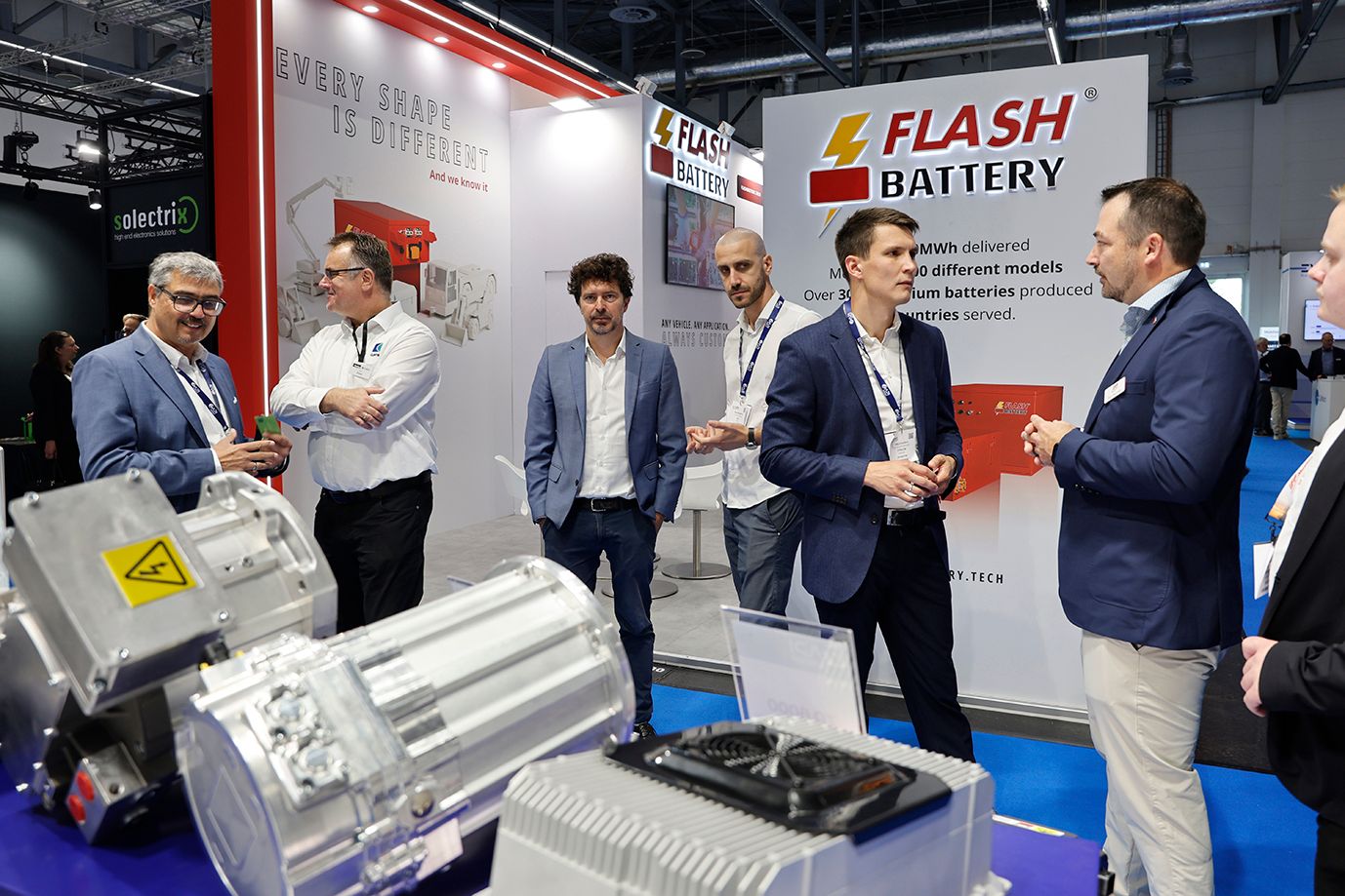 Photos shows a group of visitors networking with an exhibitor at iVT Expo Europe