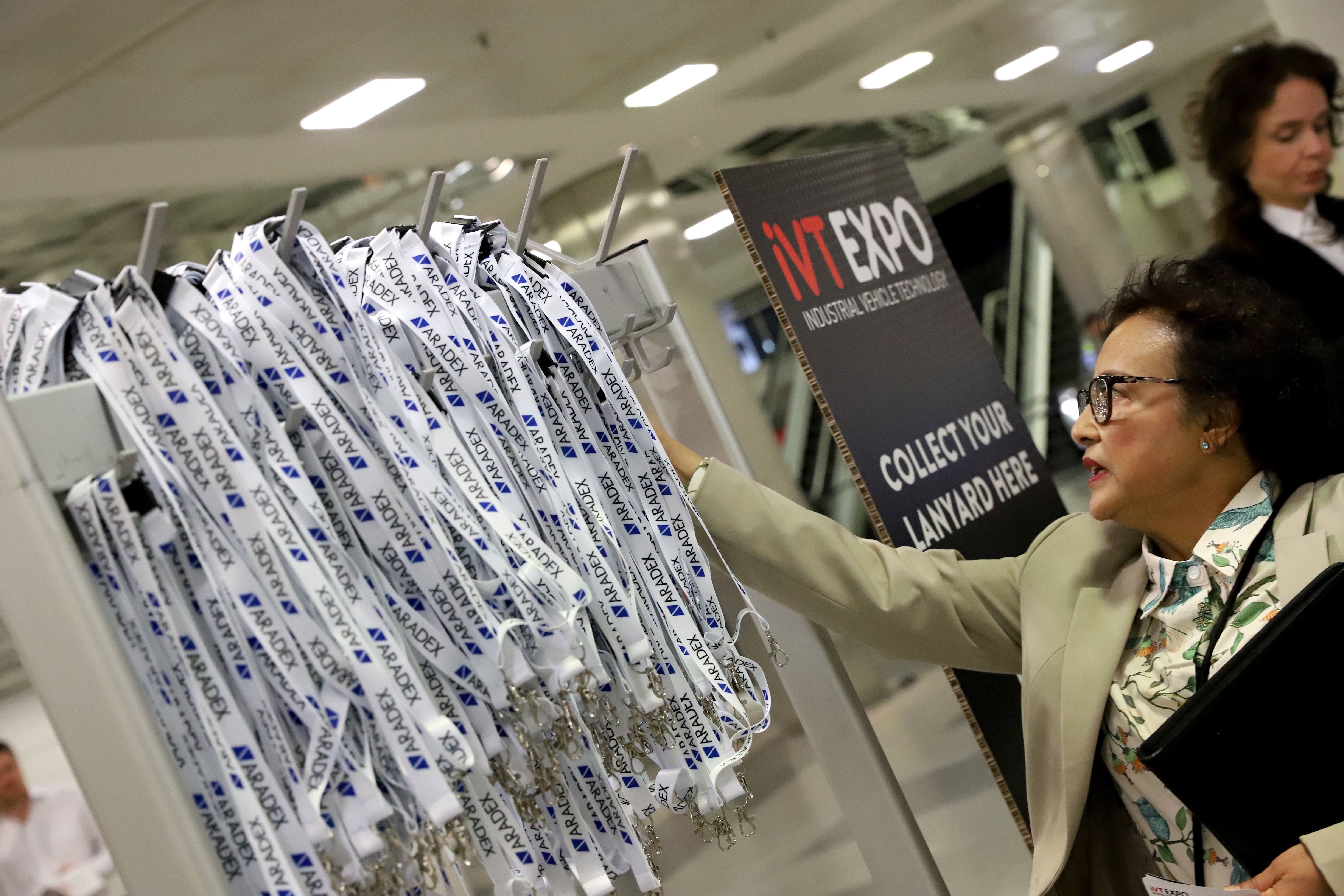Photo shows someone reaching for a lanyard at iVT Expo registration