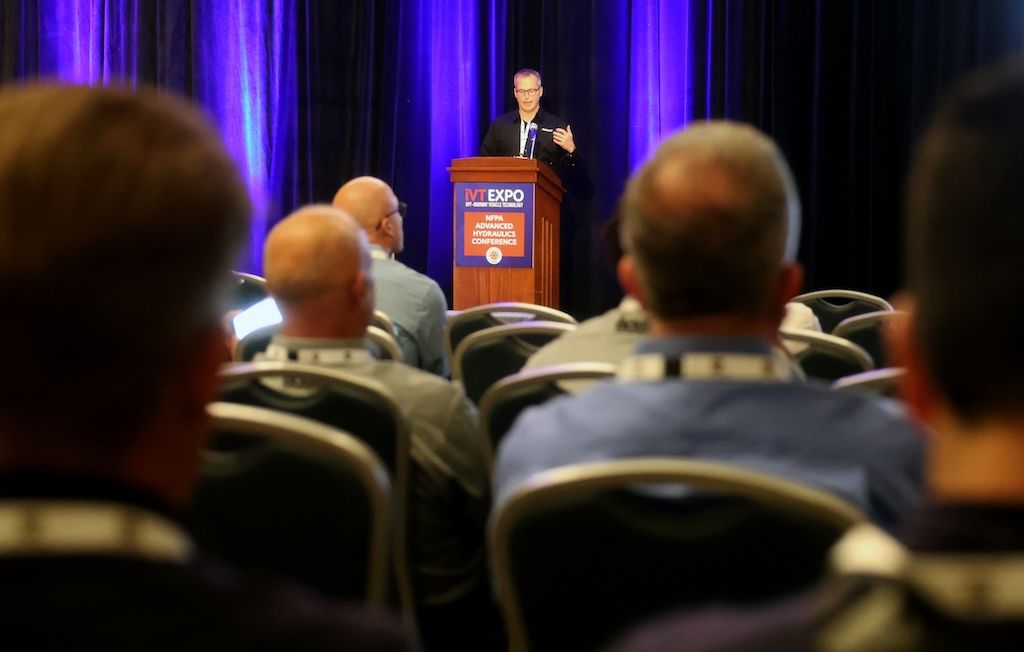 Photo shows a speaker talking to a full audience at NFPA's Advanced Hydraulics Conference at iVT Expo USA