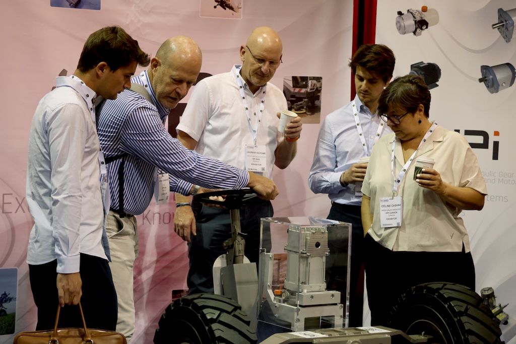 Photo shows visitors discussing a piece of tech at iVT Expo USA