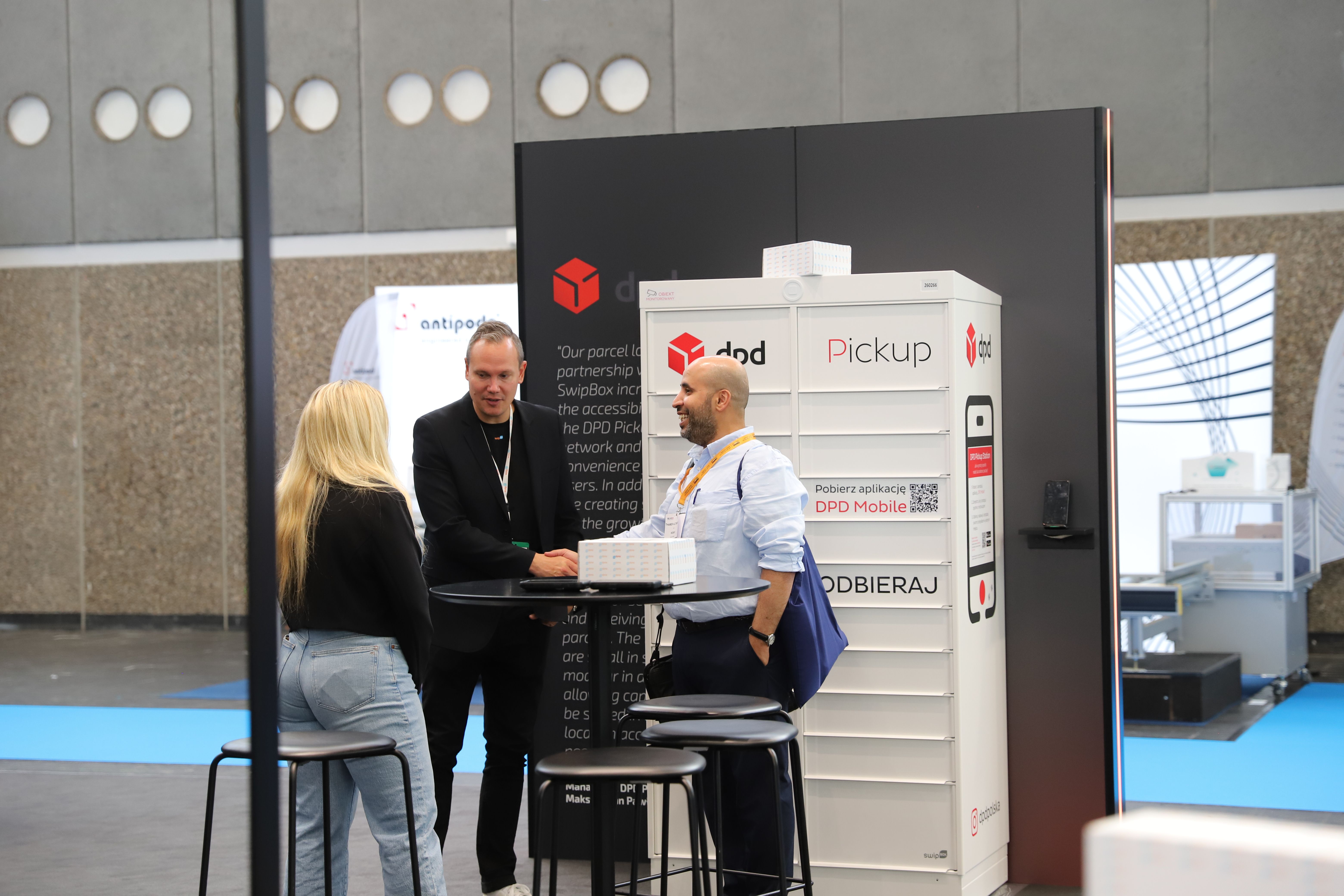 Photo shows an exhibitor at Parcel + Post Expo in conversation with a visitor