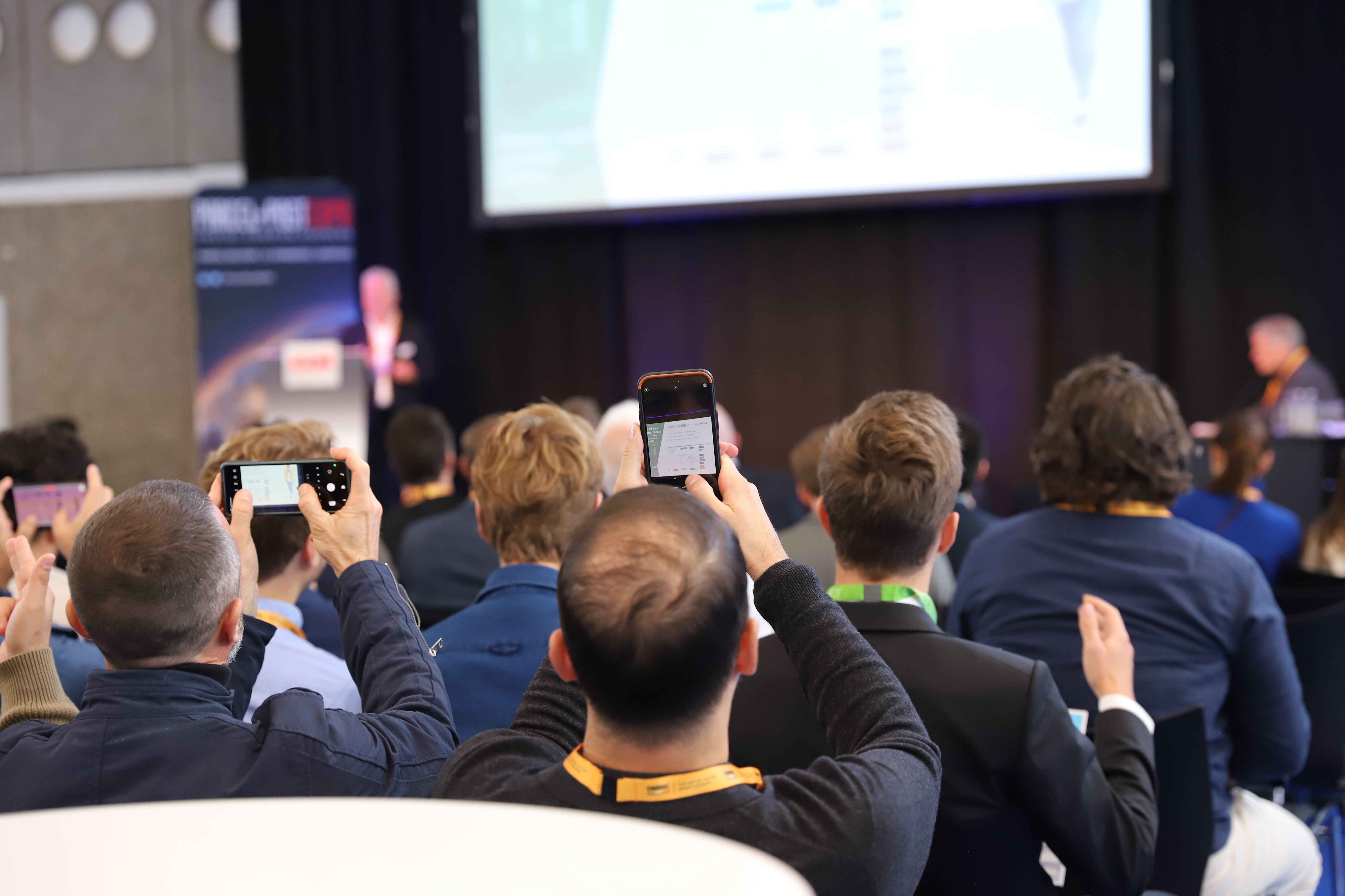 Photo shows the content stage at Parcel+Post Expo with an engaged audience in front of it