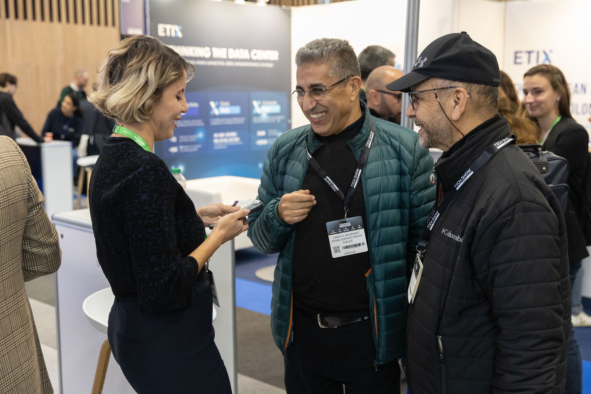 Three visitors chatting at Cloud & AI Infrastructure 2025
