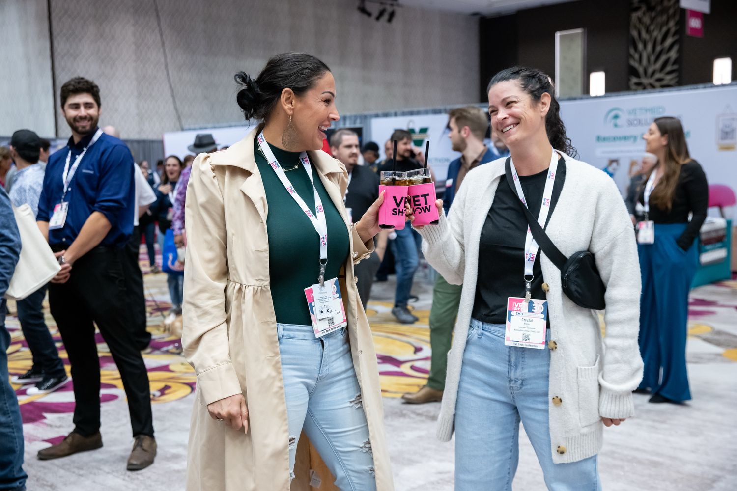 3 women smiling and enjoying drinks at the show floor mixer