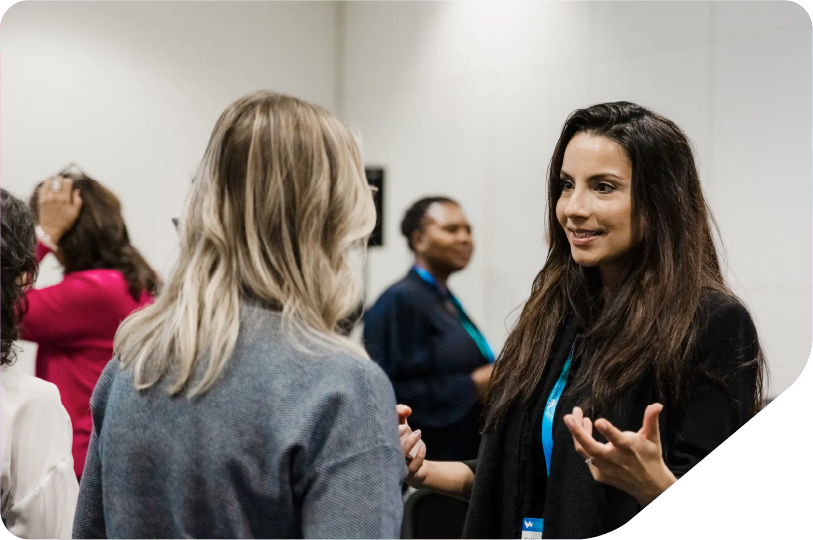 Image of two women speaking as they share ideas between them