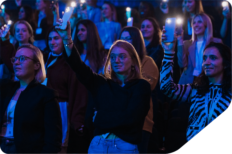 Close up image of an audience looking up at a stage looking engaged