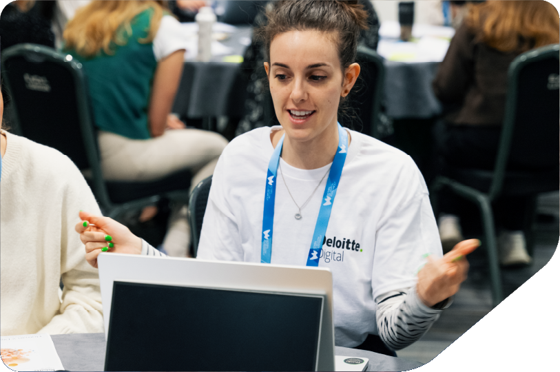 women sat around table with laptop, tables and workshop sheets problem solving