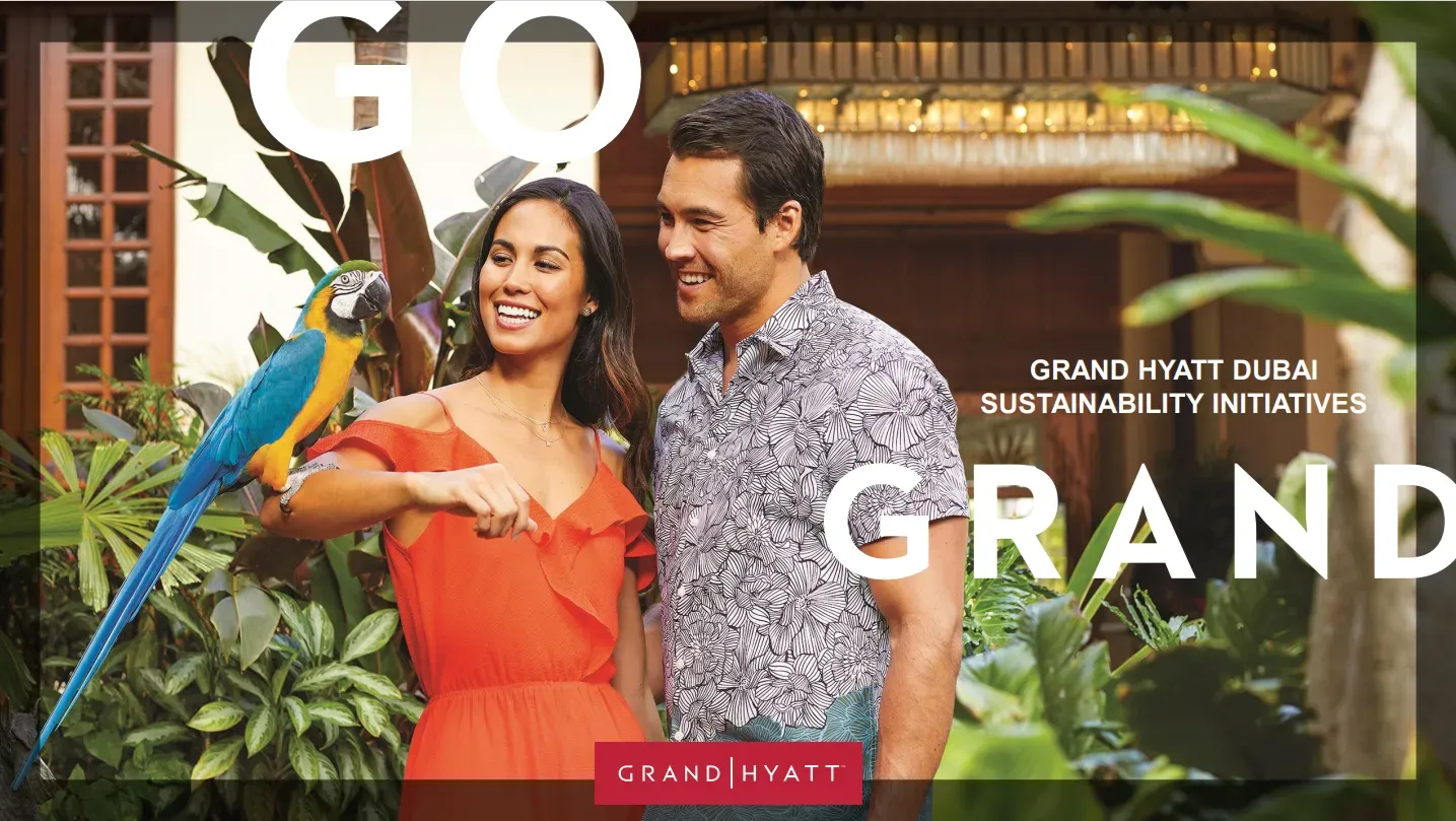 A promotional poster for Grand Hyatt Dubai Sustainability Initiatives. A smiling couple stands in a lush garden, with a vibrant blue-and-yellow macaw parrot perched on the woman's arm. Large text overlays read 