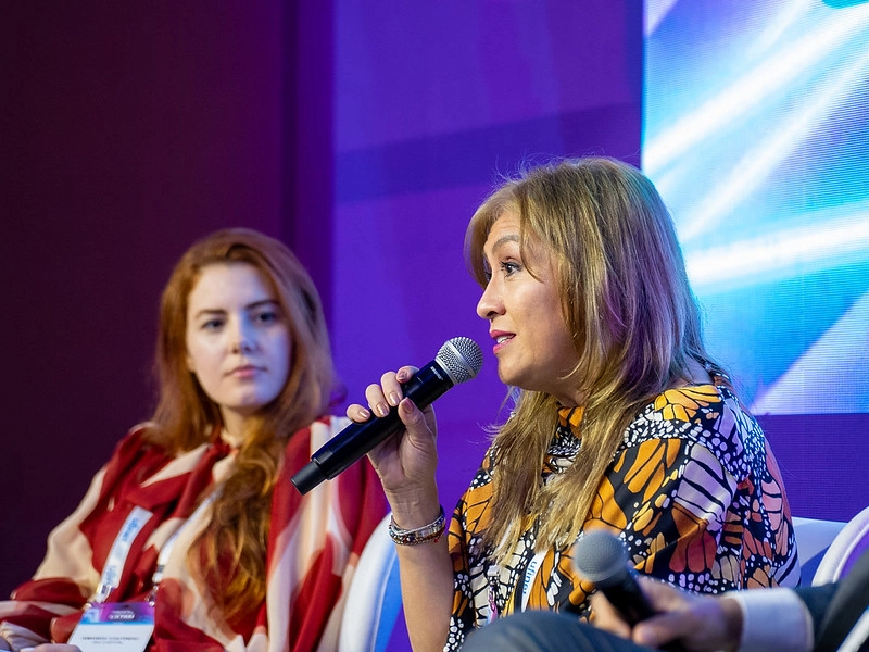 Panel speaker addressing delegates with a microphone during a panel session at Capacity LATAM.