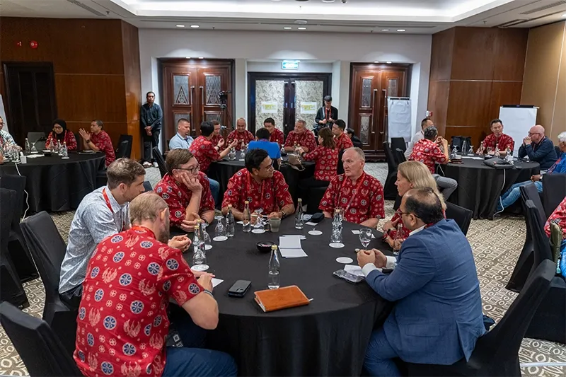 A room full of people on a round table, discussing building AI initiatives with partners. GLF Batic in Bali 2026