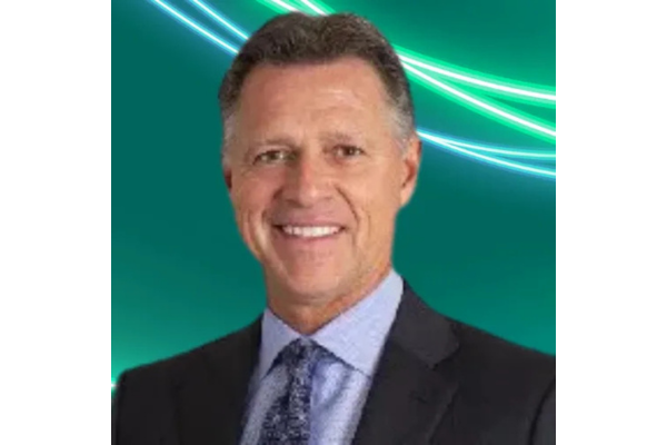 Professional headshot Steve Smith with short, slicked-back brown hair, wearing a dark suit, a light blue shirt, and a dark patterned tie. The background is teal with glowing green and white abstract lines curving across the top.