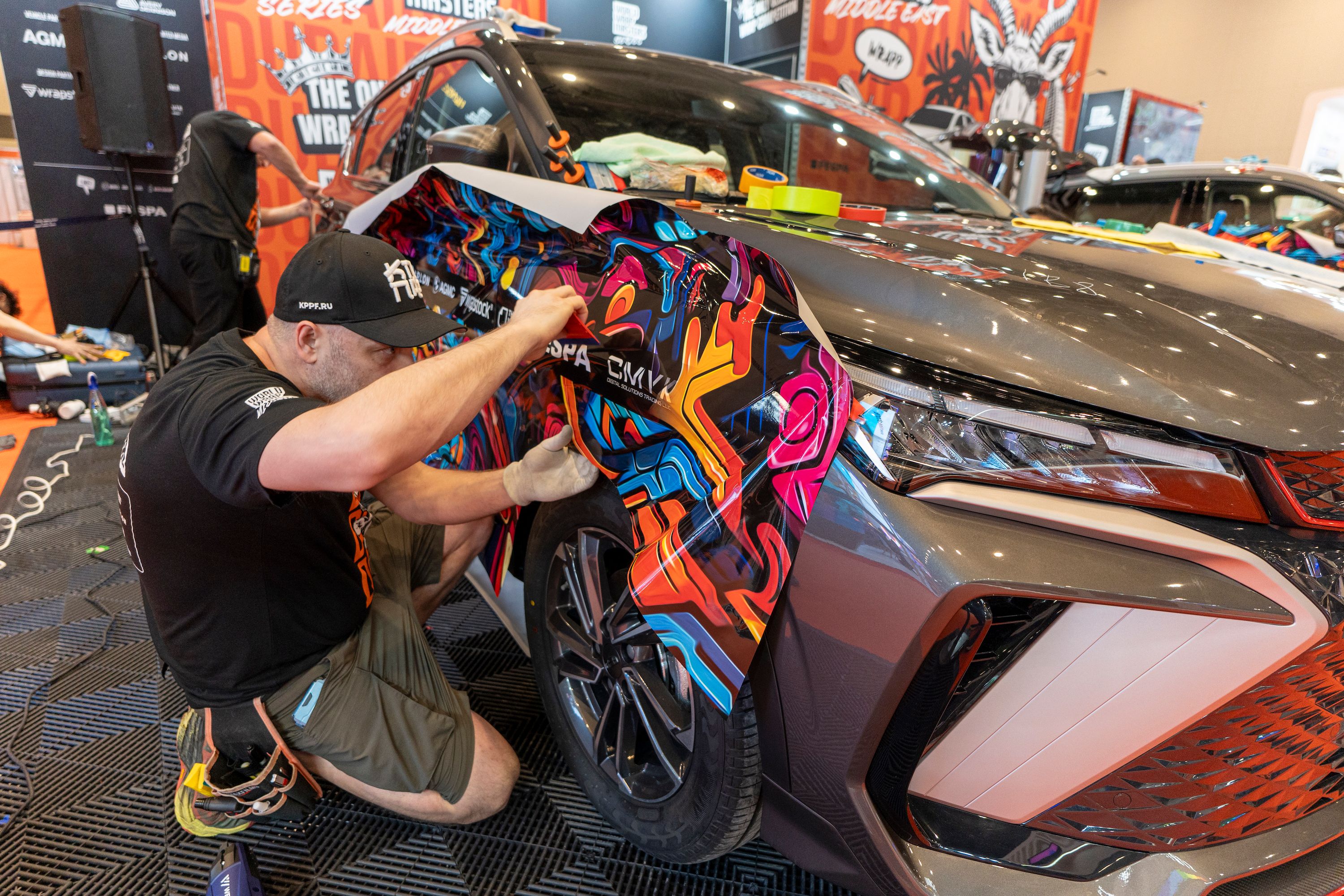 Person applying vinyl film to a vehicle in the World Wrap Masters Middle East competition